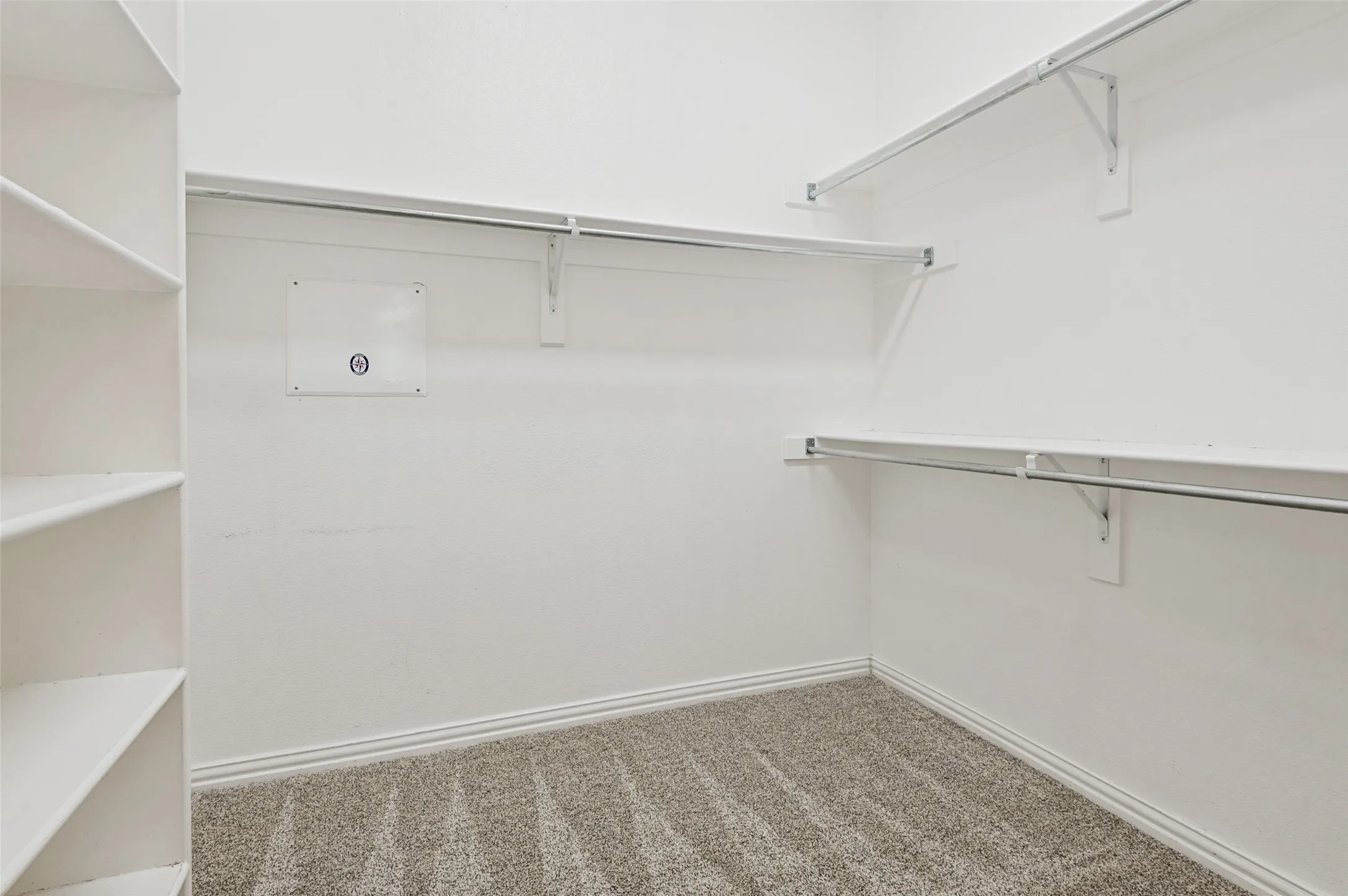 Walk-in closet featuring built-in shelving, white walls, carpet flooring, and multiple clothing rods...fabulous!!!