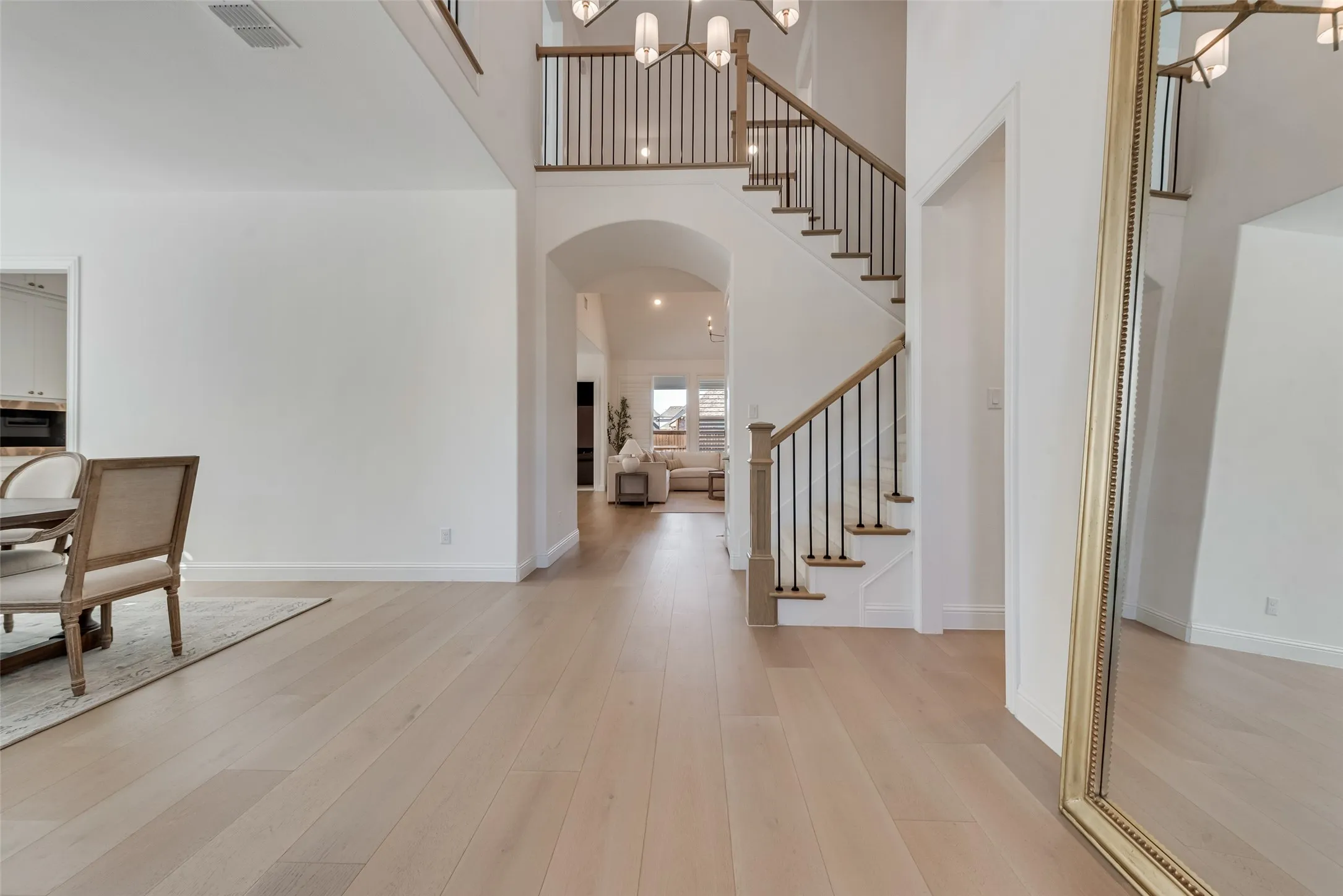Grand Foyer with open staircase and white oak hardwoods flow seamlessly into this formal dining and office, before entering the living room and kitchen.