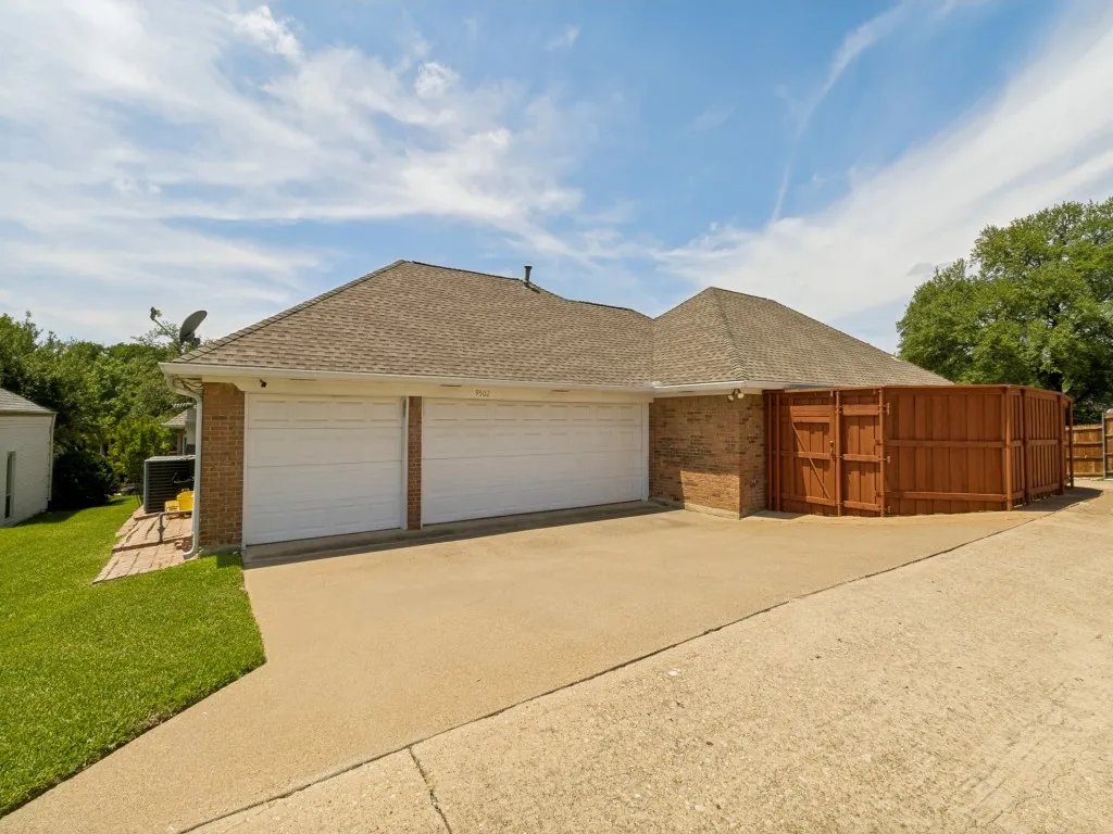 This view of the three-car garage shows access to side yard through a gate!