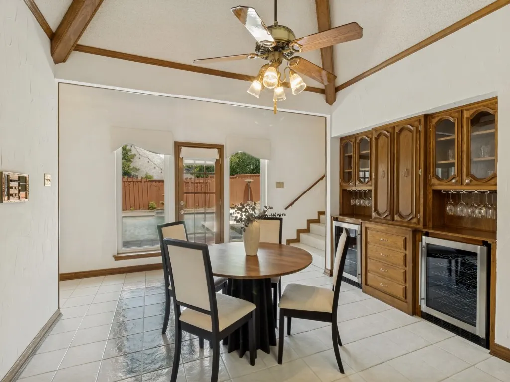The breakfast room is appointed with built-in cabinetry, dual wine refrigerators, wine racks, and peaceful pool views!