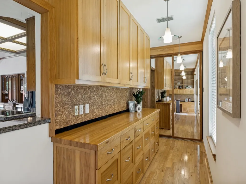 Just beyond the office, a hallway carries the red oak flooring and includes additional built-in storage!