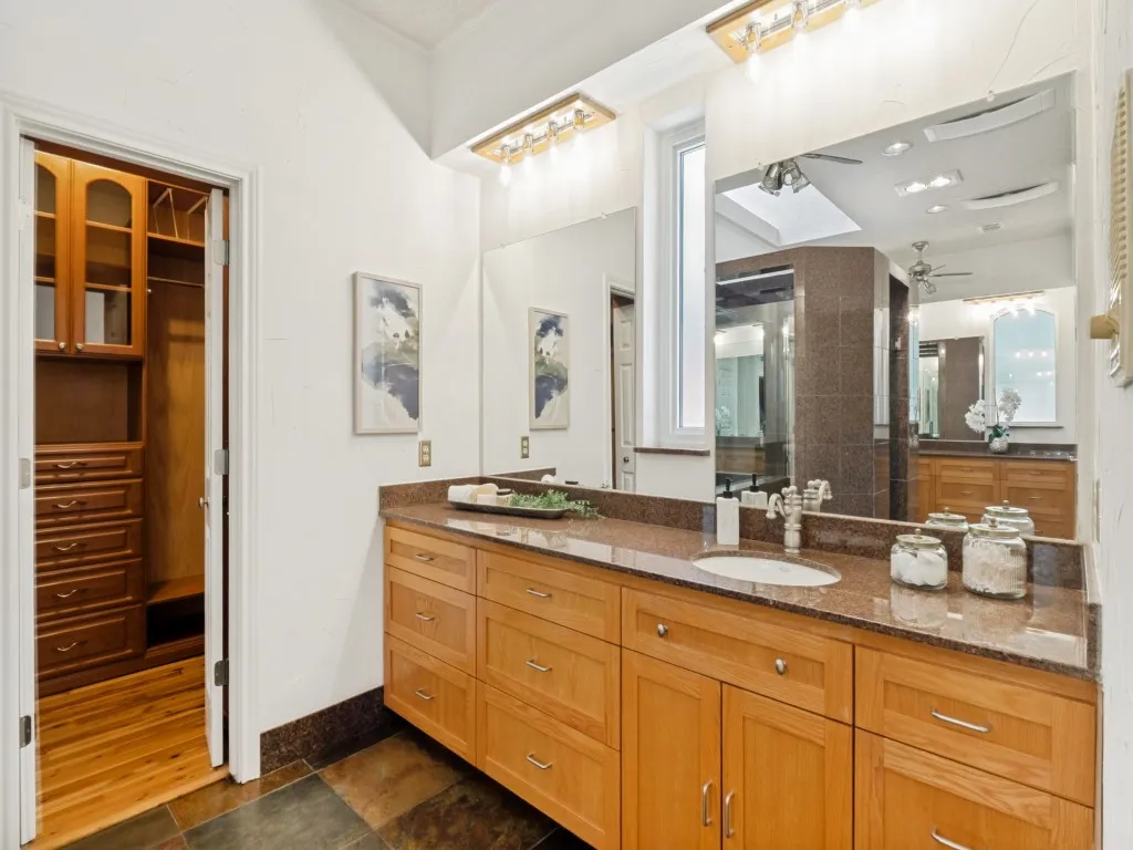 This additional view of the primary bath emphasizes the custom red oak cabinetry adorning both vanities!