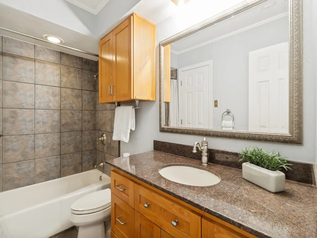 The guest wing includes an additional full bath with a granite counter and custom red oak cabinetry!