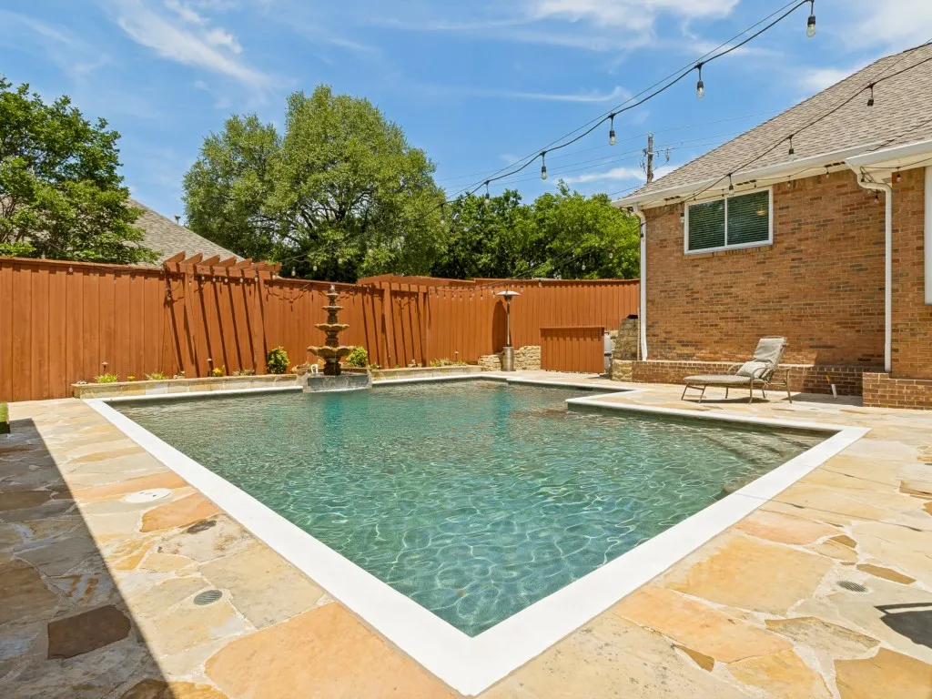 This view captures the pool’s water fountain, enhanced by a raised flower bed ideal for your green-thumb pursuits!