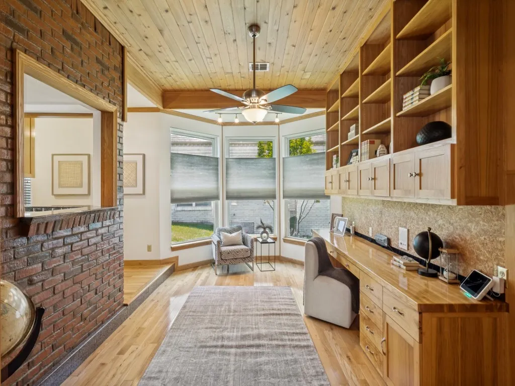 The office showcases red oak floors, custom hickory cabinetry and shelving, exposed brick, and distinctive granite baseboards!