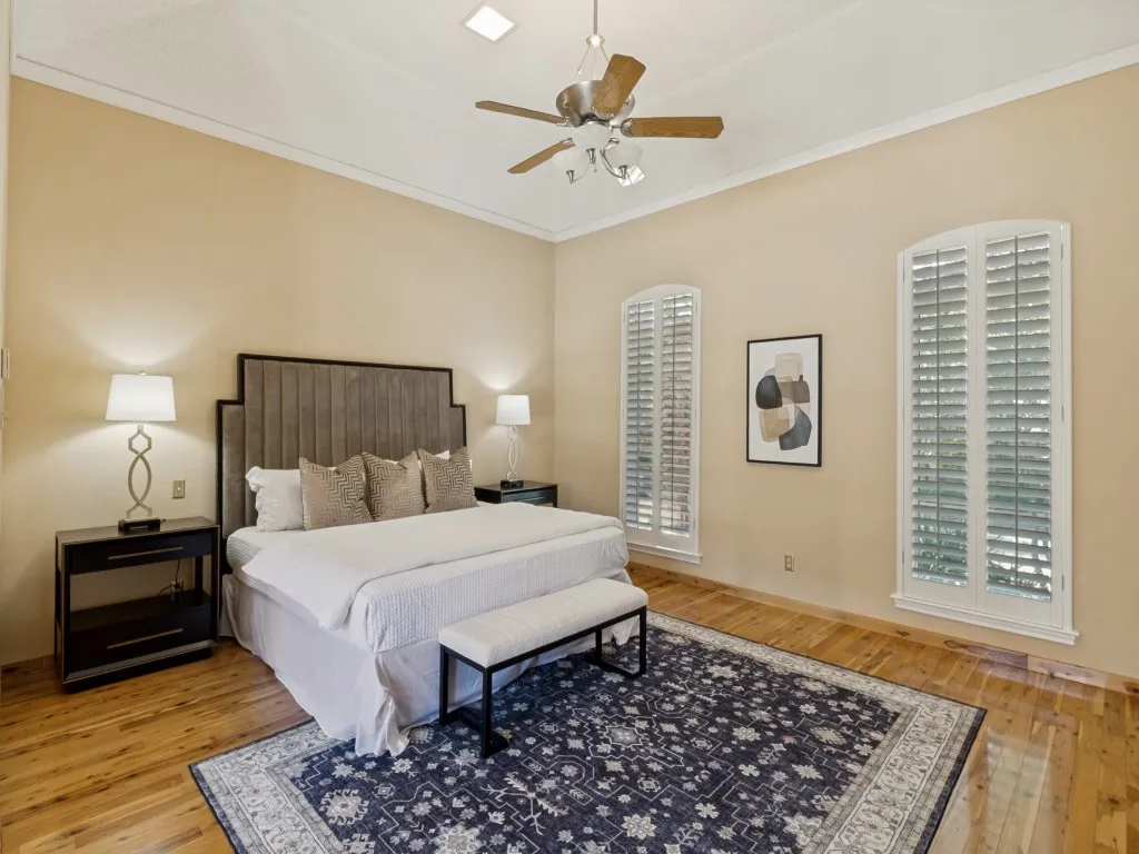 Privately situated from the guest bedrooms, the primary suite features Australian cypress wood floors, plantation shutters, space for a sitting area and two ceiling-recessed Martin Logan speakers!