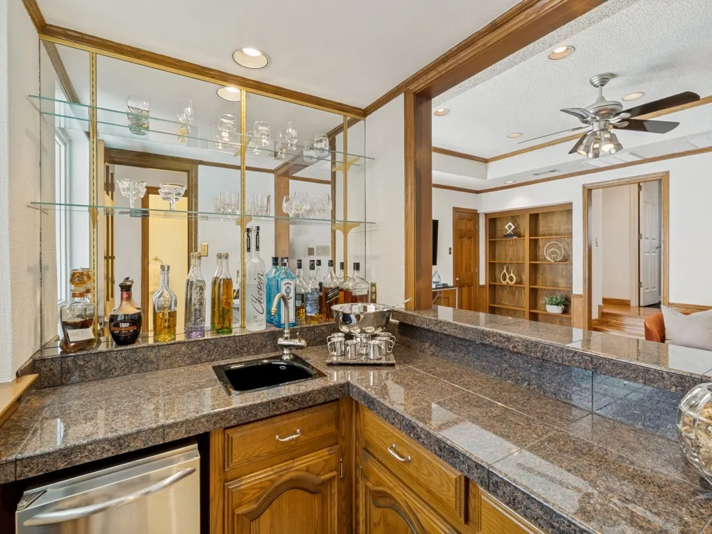 The wet bar features a two-stage water filtration system, an ice maker delivering Sonic-style ice, a sink, and ample cabinetry for storage!