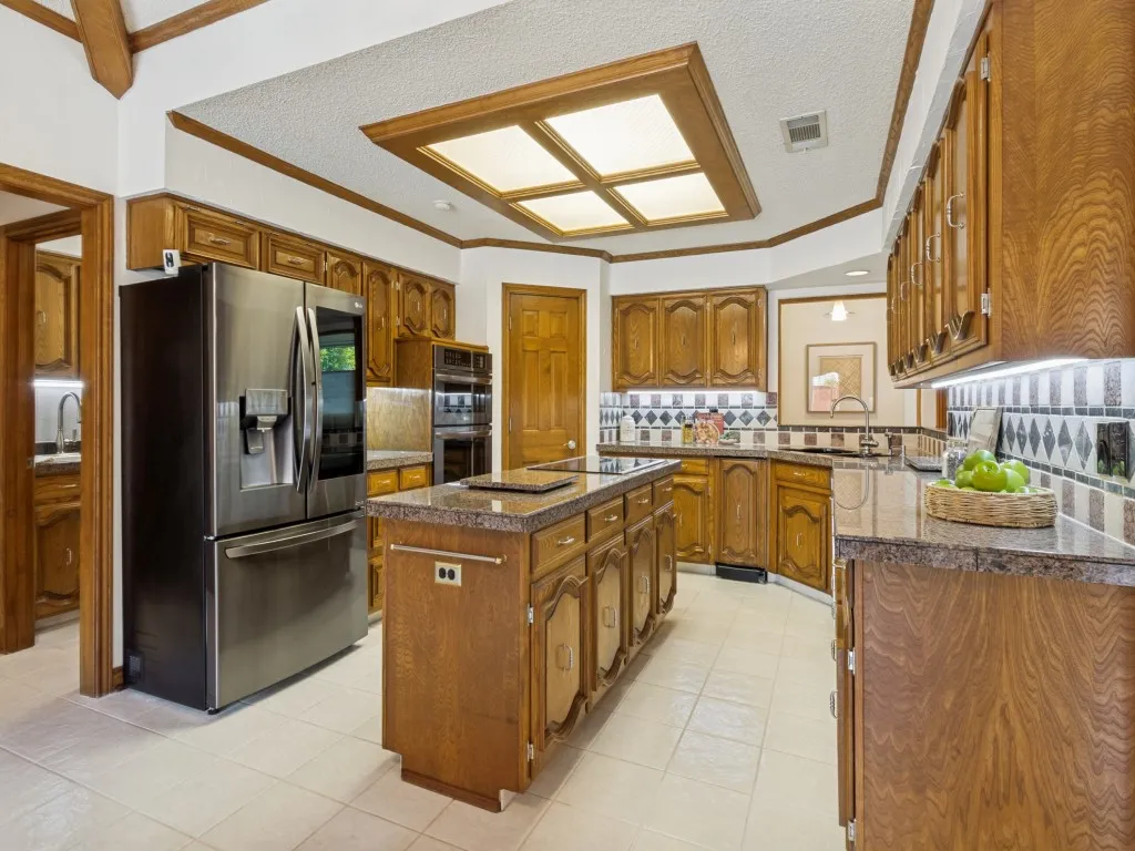 Thoughtfully designed for both everyday cooking and entertaining, the kitchen showcases a granite island and countertops, ample storage, a double sink, and black stainless steel appliances!