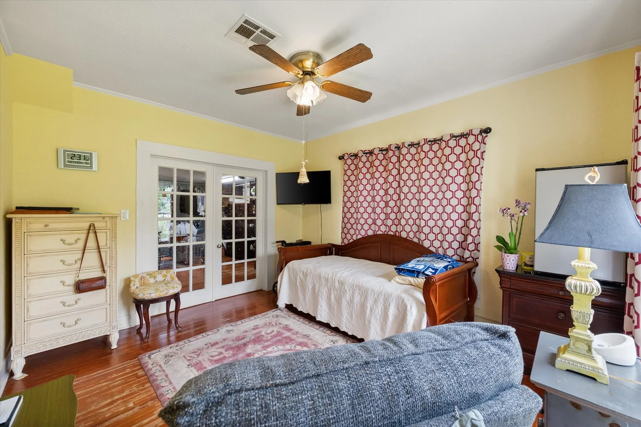French doors with multiple lites, wood-finish flooring, and a ceiling fan with integrated lighting