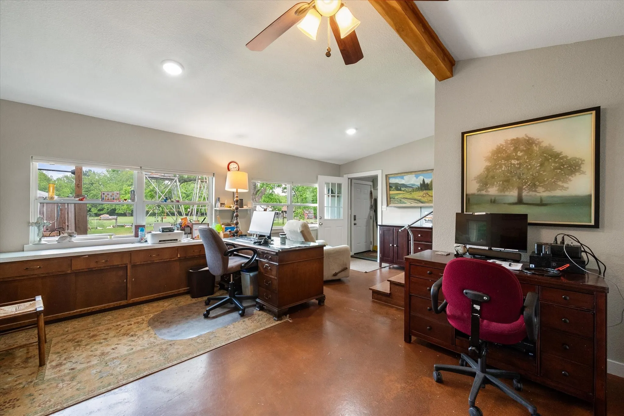 Spacious room featuring rich wood-finish flooring, recessed lighting, and a ceiling fan with integrated light