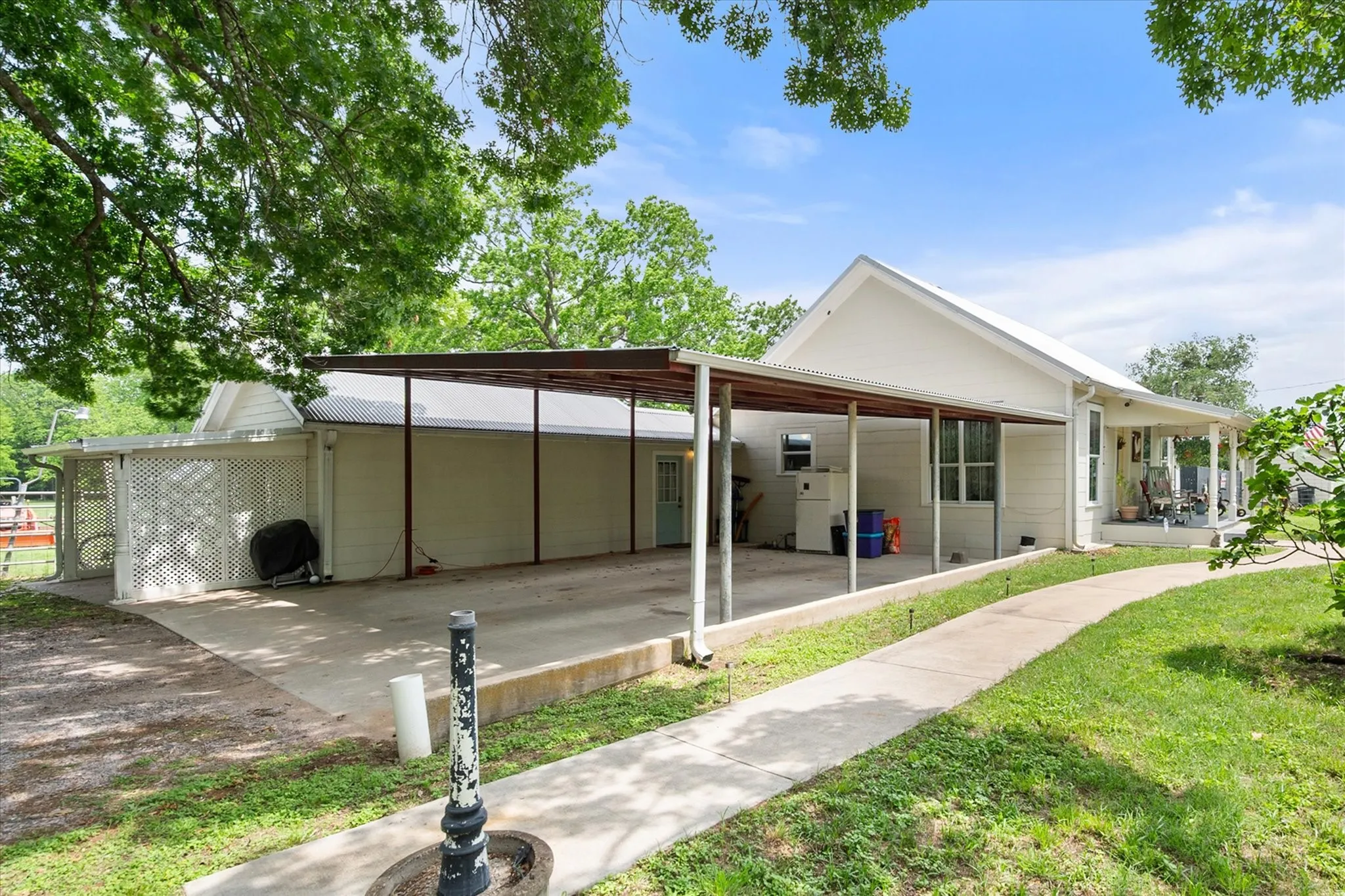 Exterior featuring a covered carport, concrete driveway, and a covered front porch