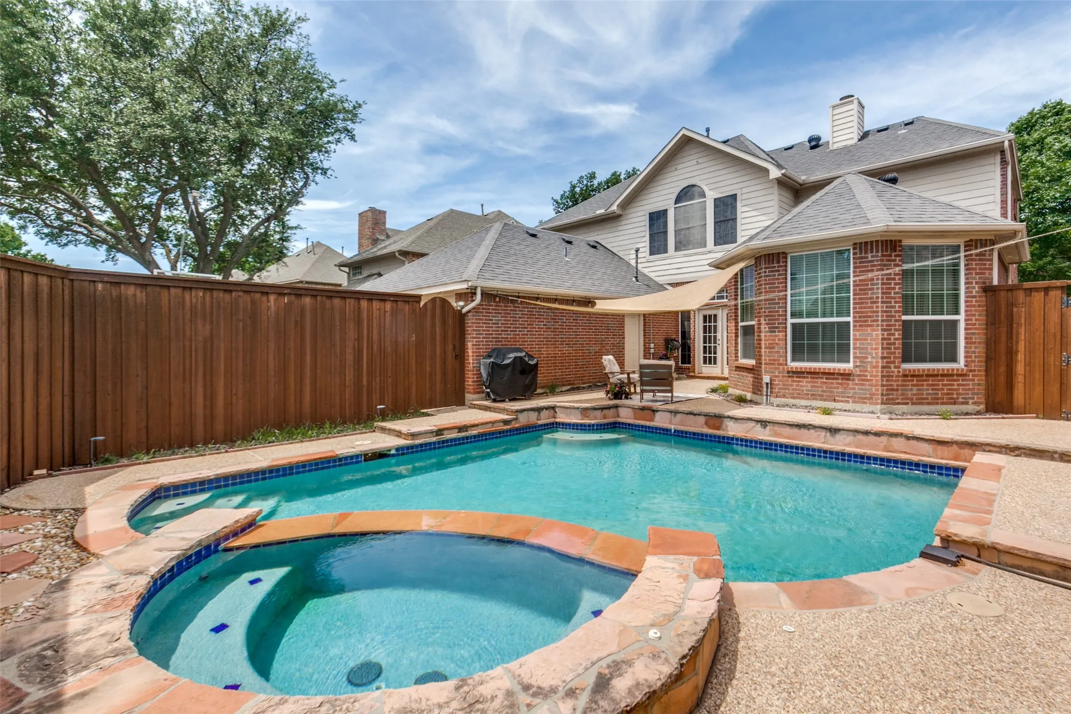 Expansive backyard featuring a built-in swimming pool and spa with flagstone coping