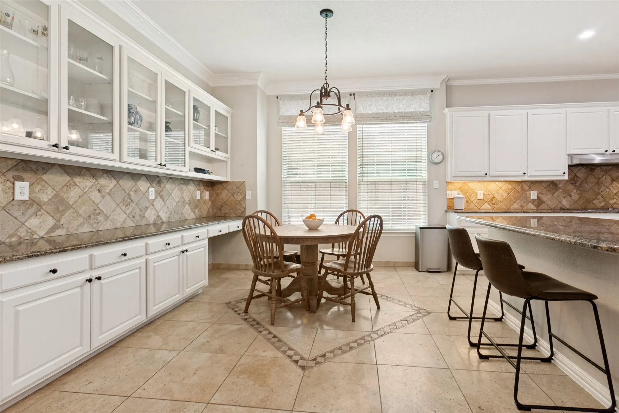 Kitchen & Breakfast Room with white cabinetry, stone tile flooring, granite countertops, and upper and lower cabinets.