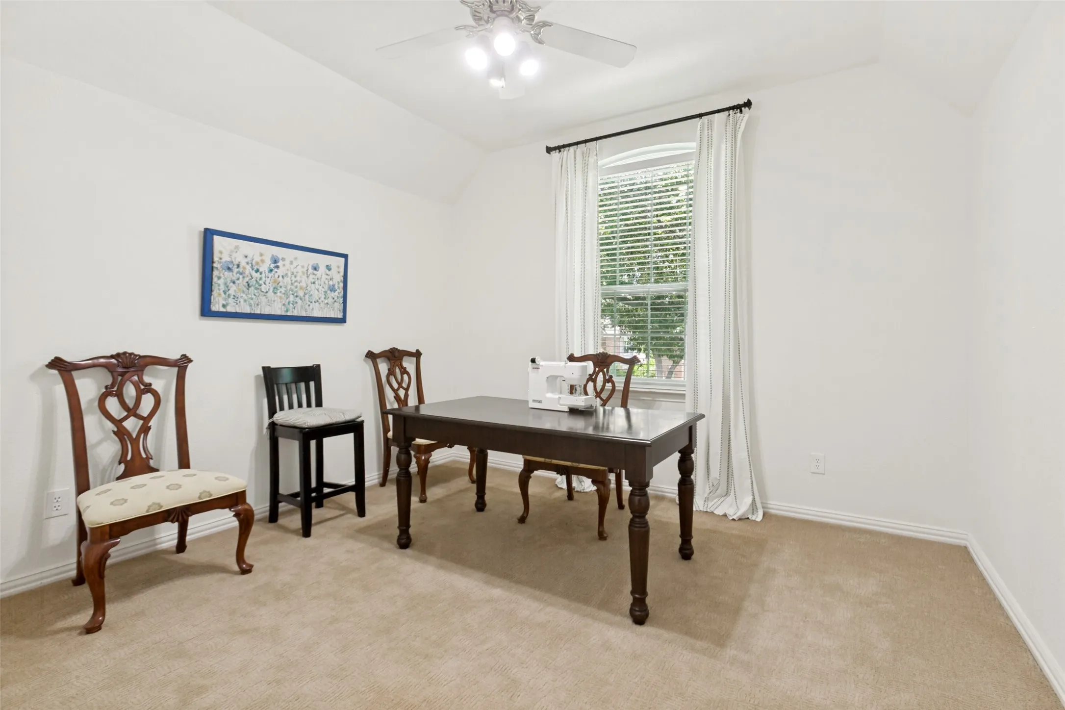 Upstairs bedroom with a vaulted ceiling and a ceiling fan