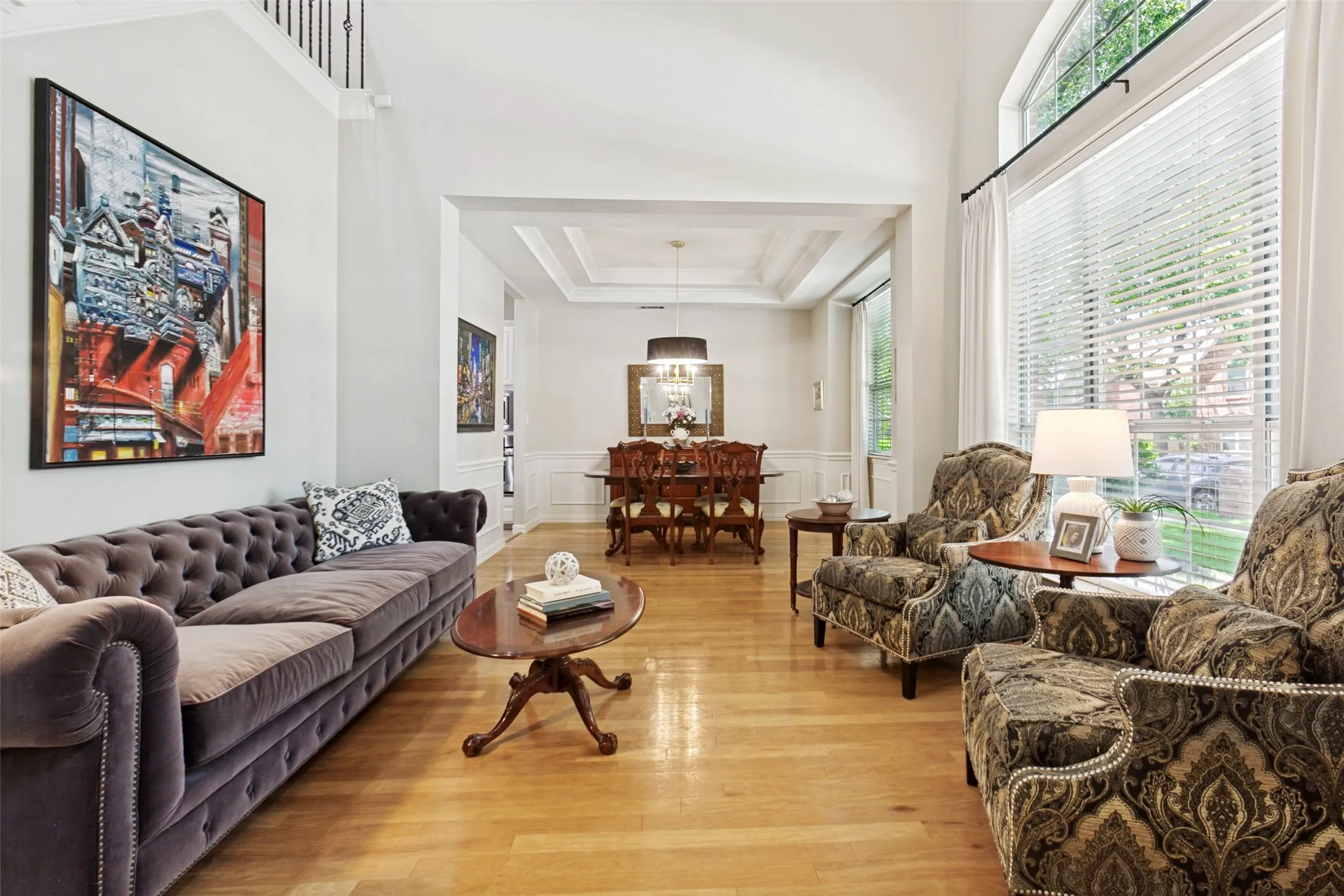Light wood-finish flooring extending into a formal dining area with a coffered ceiling