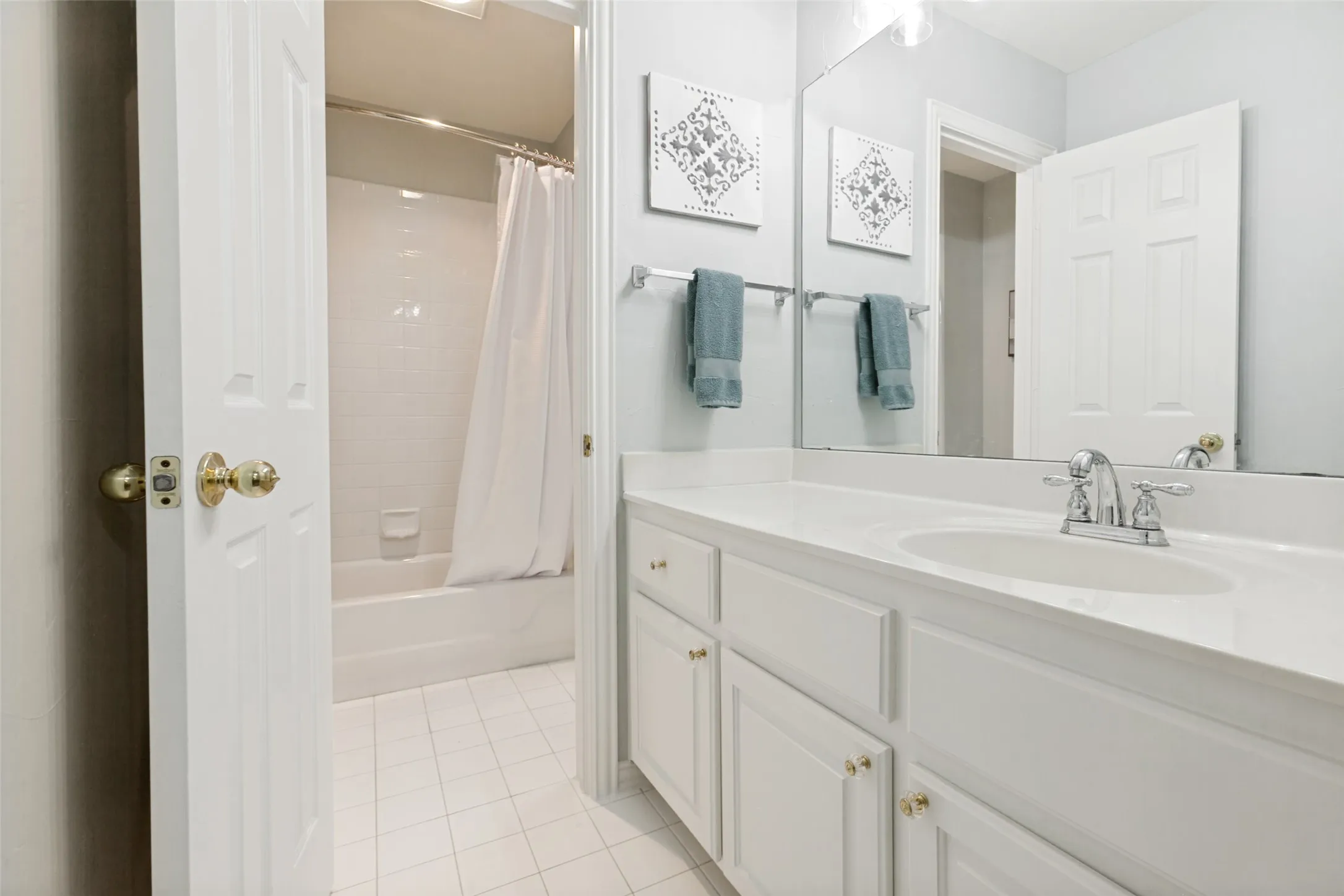 Jack and Jill bathroom featuring a single vanity with an integrated sink, polished chrome faucet, a large wall-mounted mirror and updated light fixture