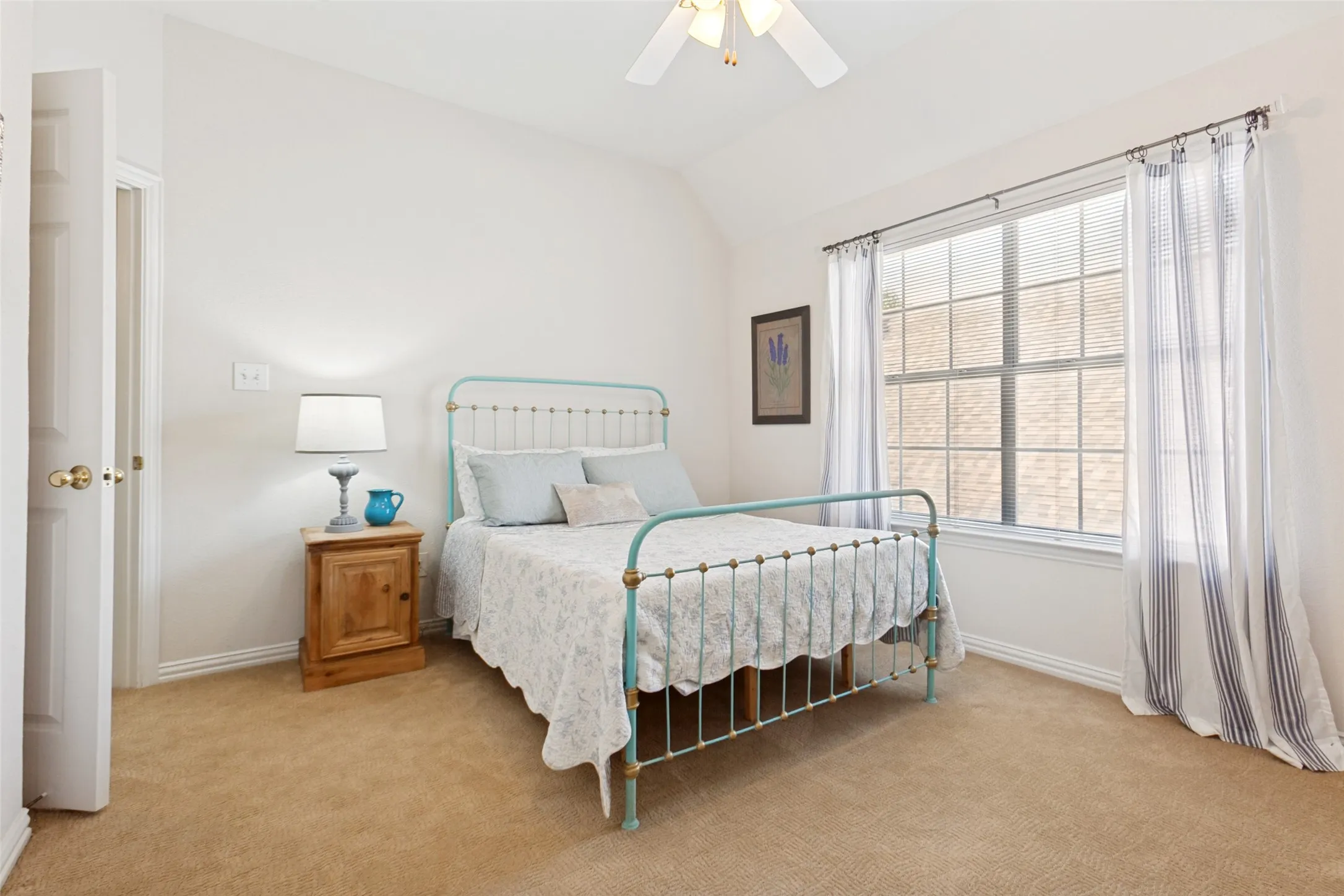 Upstairs split bedroom featuring a vaulted ceiling and a ceiling fan