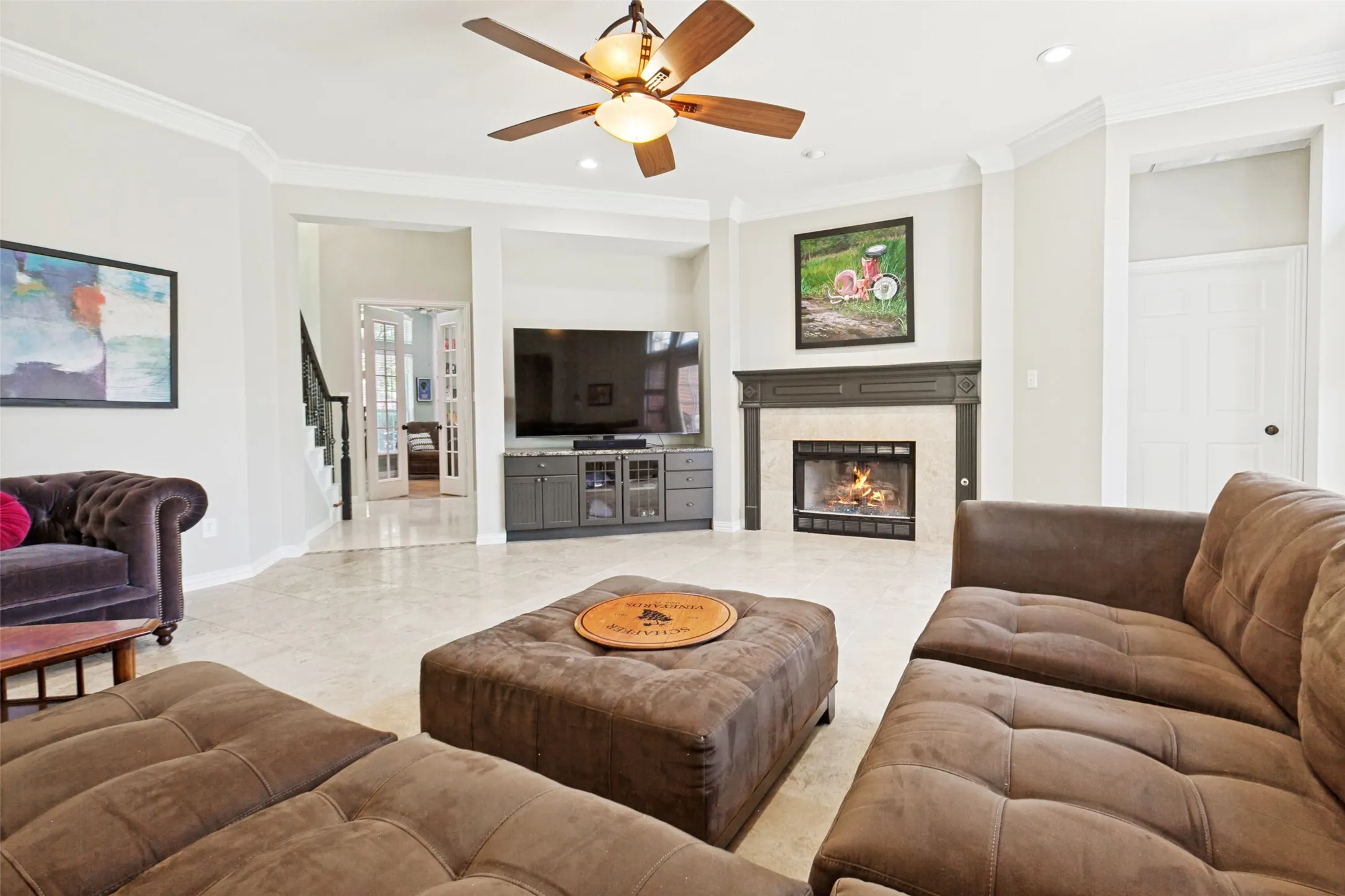 Spacious living area featuring a central fireplace with a stone surround and dark wood mantel