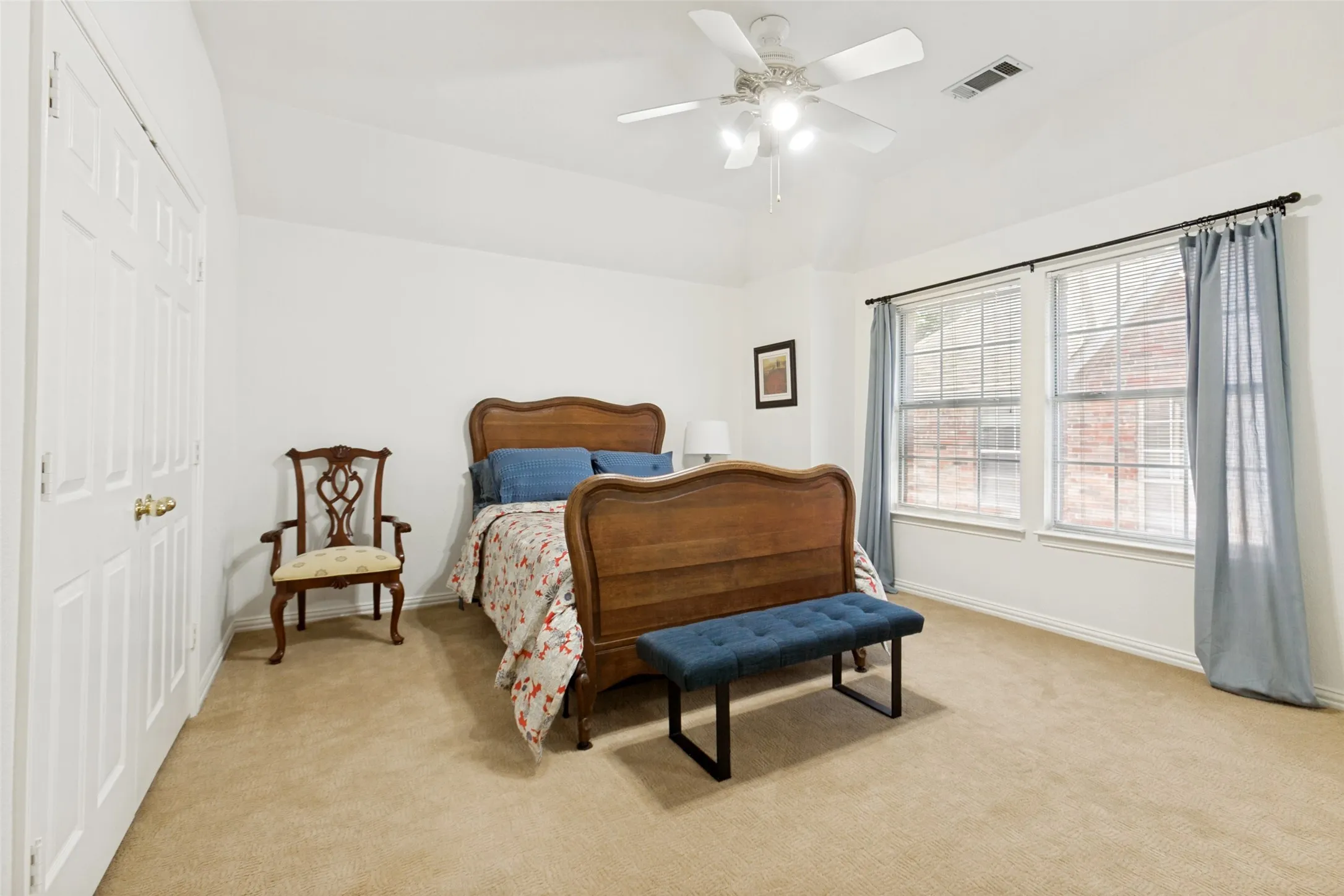 Upstairs bedroom featuring a vaulted ceiling and a ceiling fan with integrated lighting