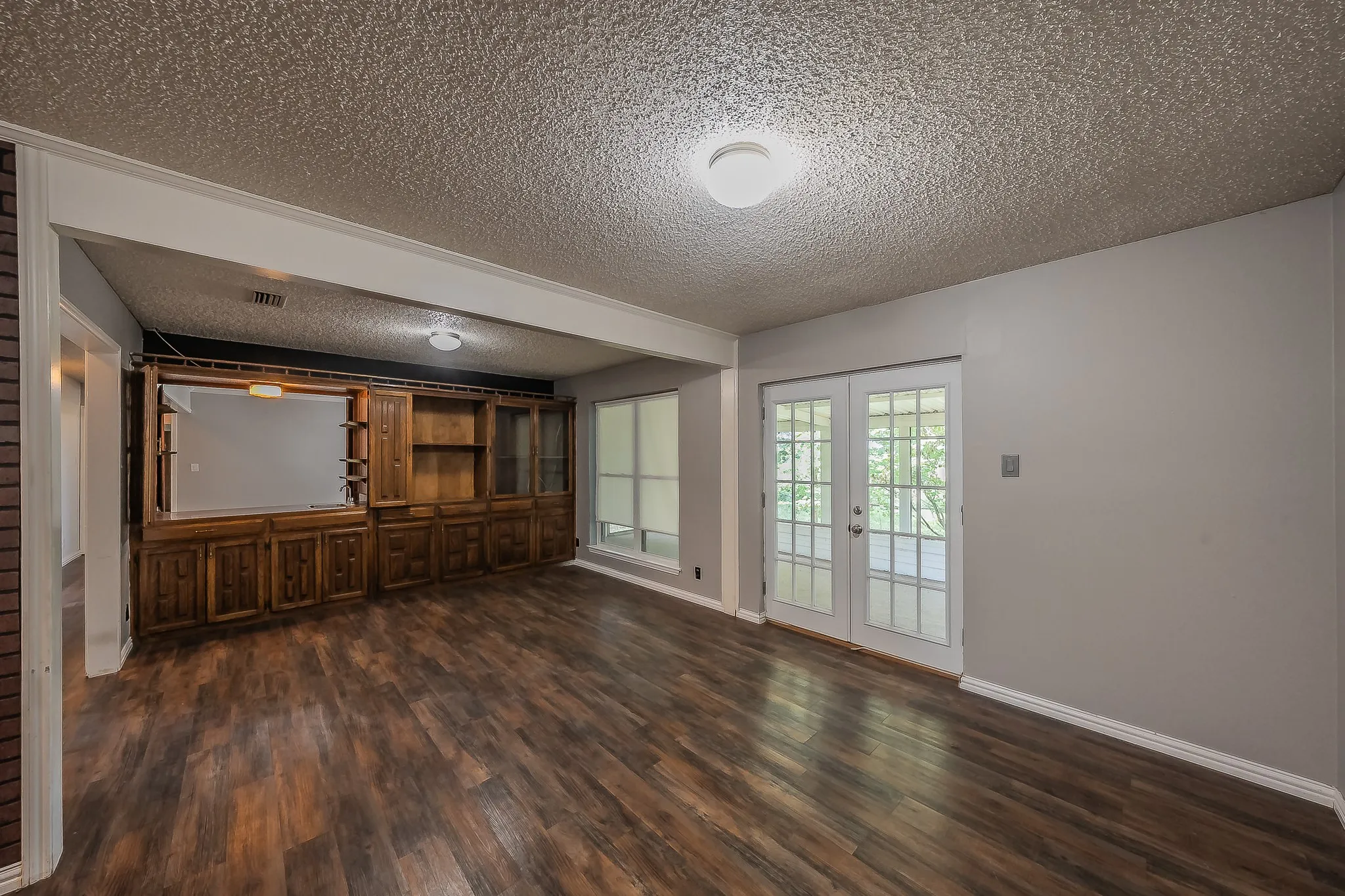 Spacious room featuring wood-finish flooring and neutral wall tones