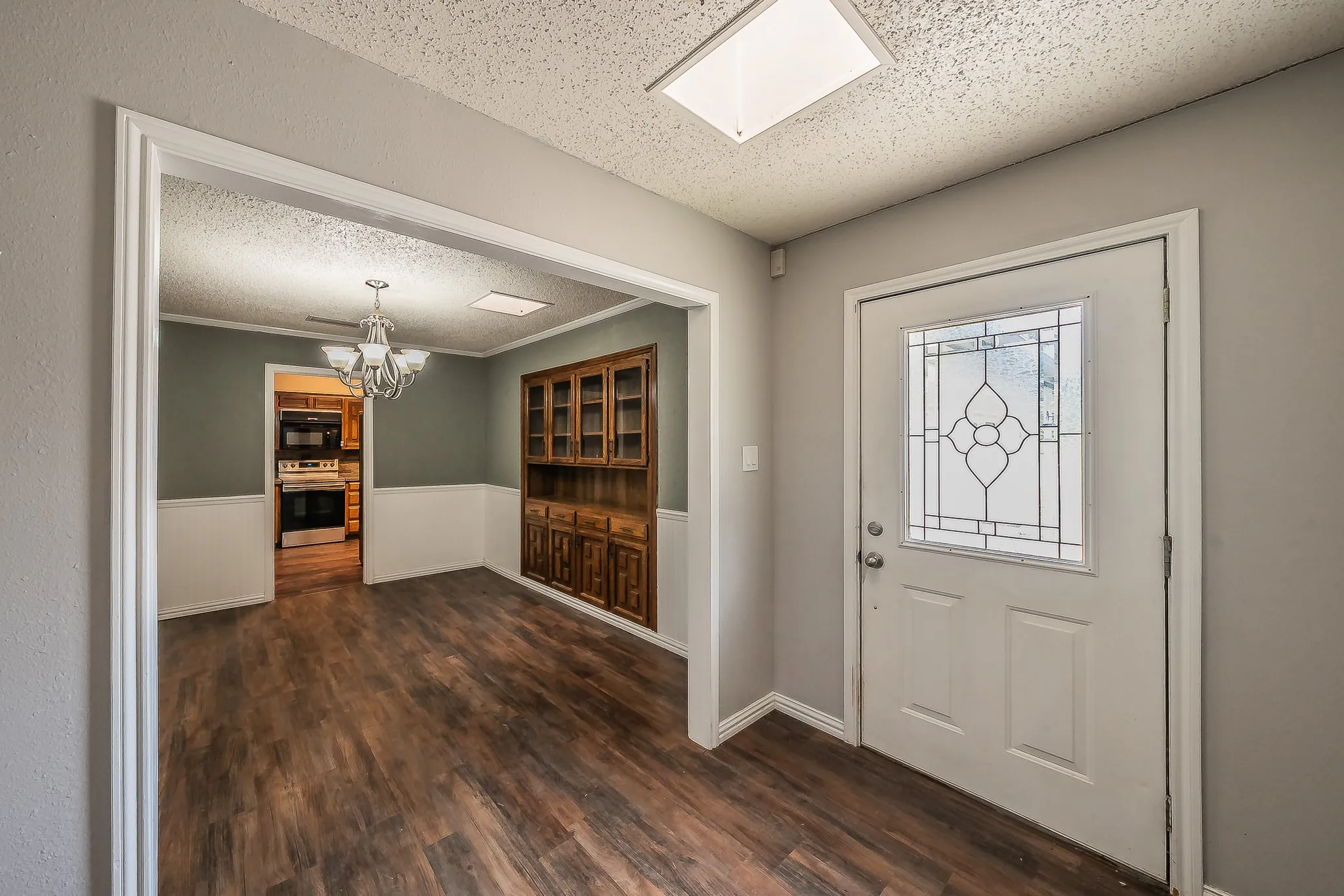 Entryway featuring a white door with decorative glass insert, wood-finish flooring, and recessed ceiling lighting