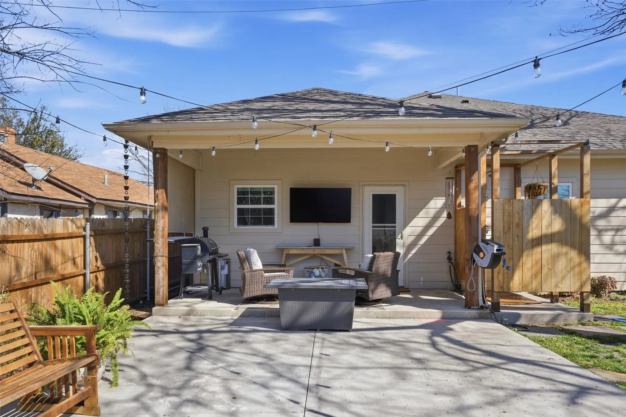Covered patio with exposed wood posts, concrete flooring, and recessed lighting