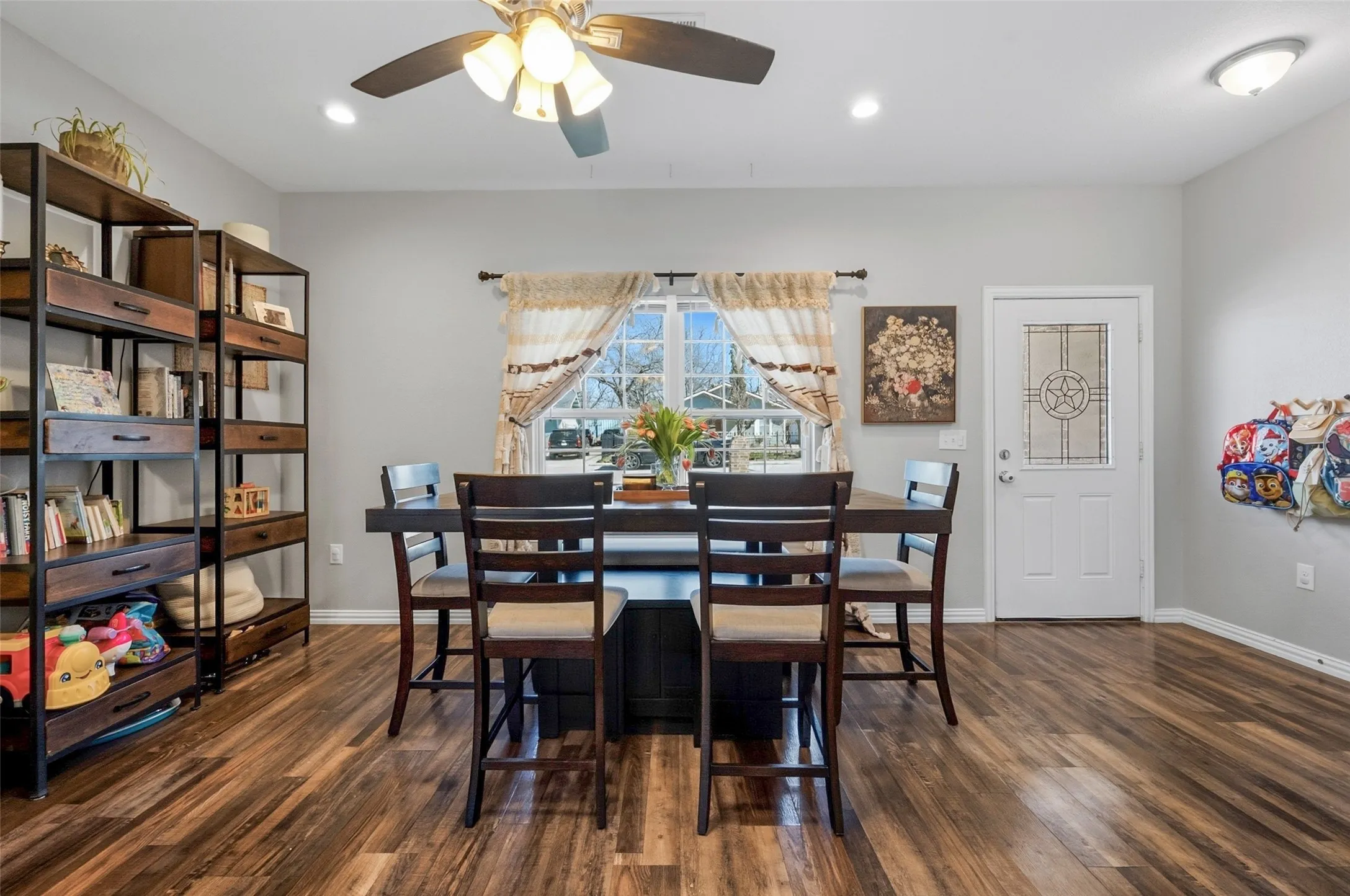Bright interior space featuring wood-finish flooring, light gray walls, and a multi-pane window with exterior views