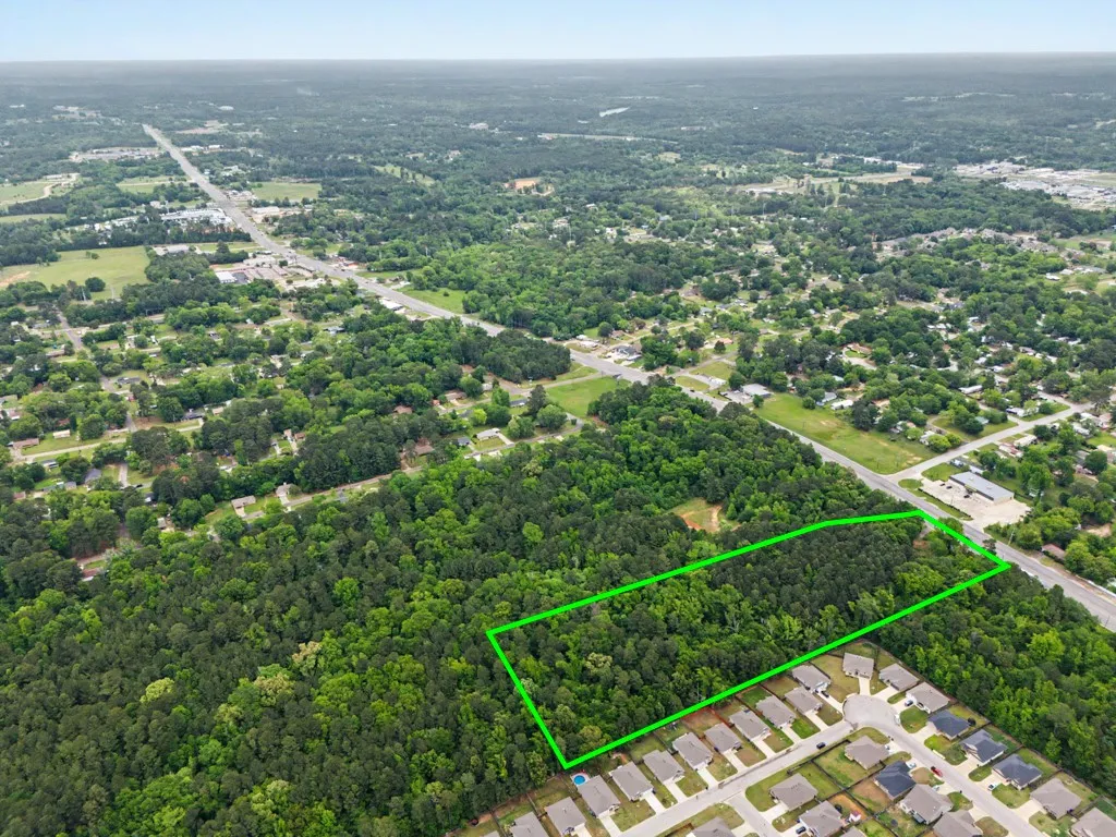 Expansive wooded acreage outlined in green, featuring mature trees and a substantial land footprint