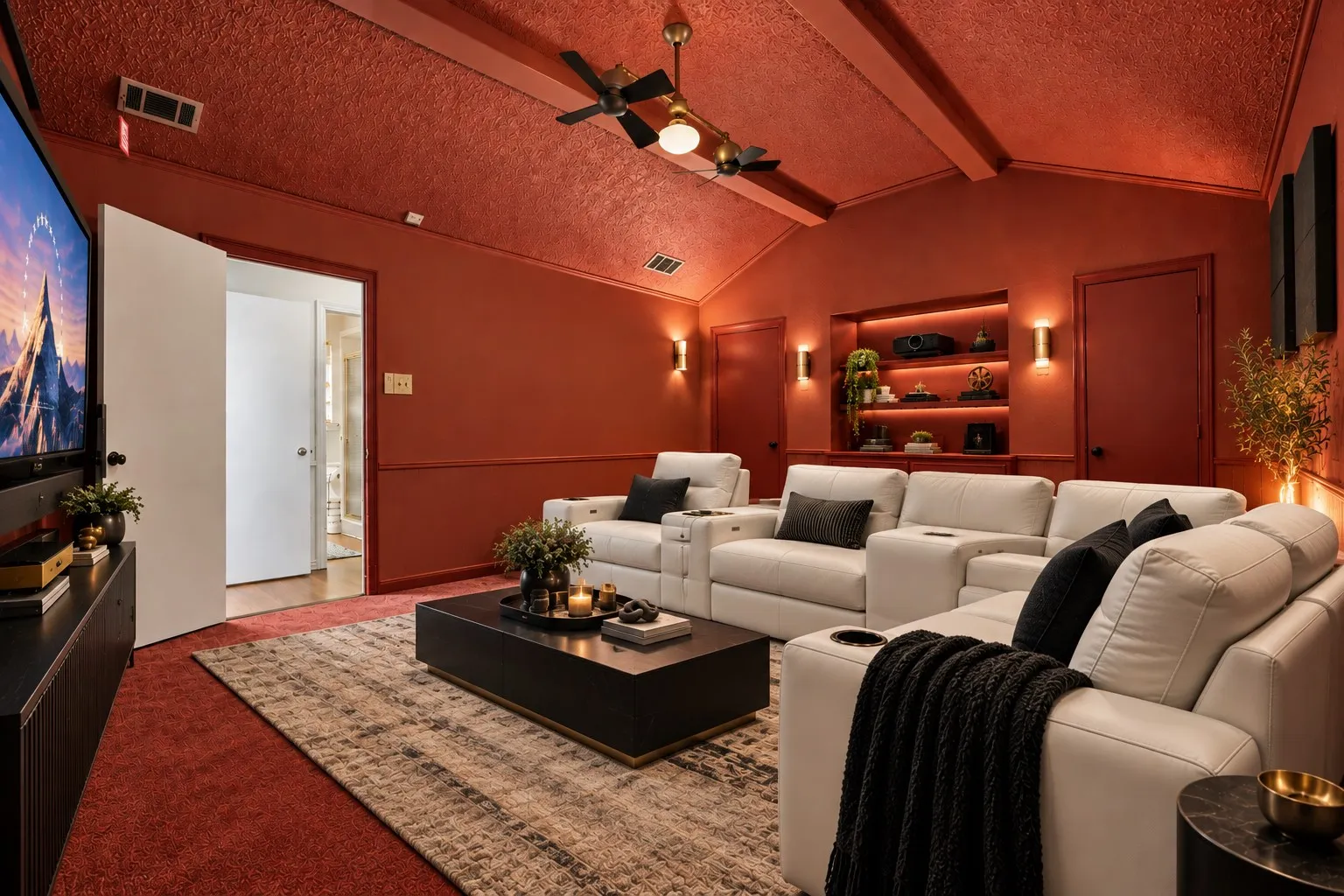 Vaulted ceiling with exposed beams, built-in recessed shelving with accent lighting, and integrated ceiling fan