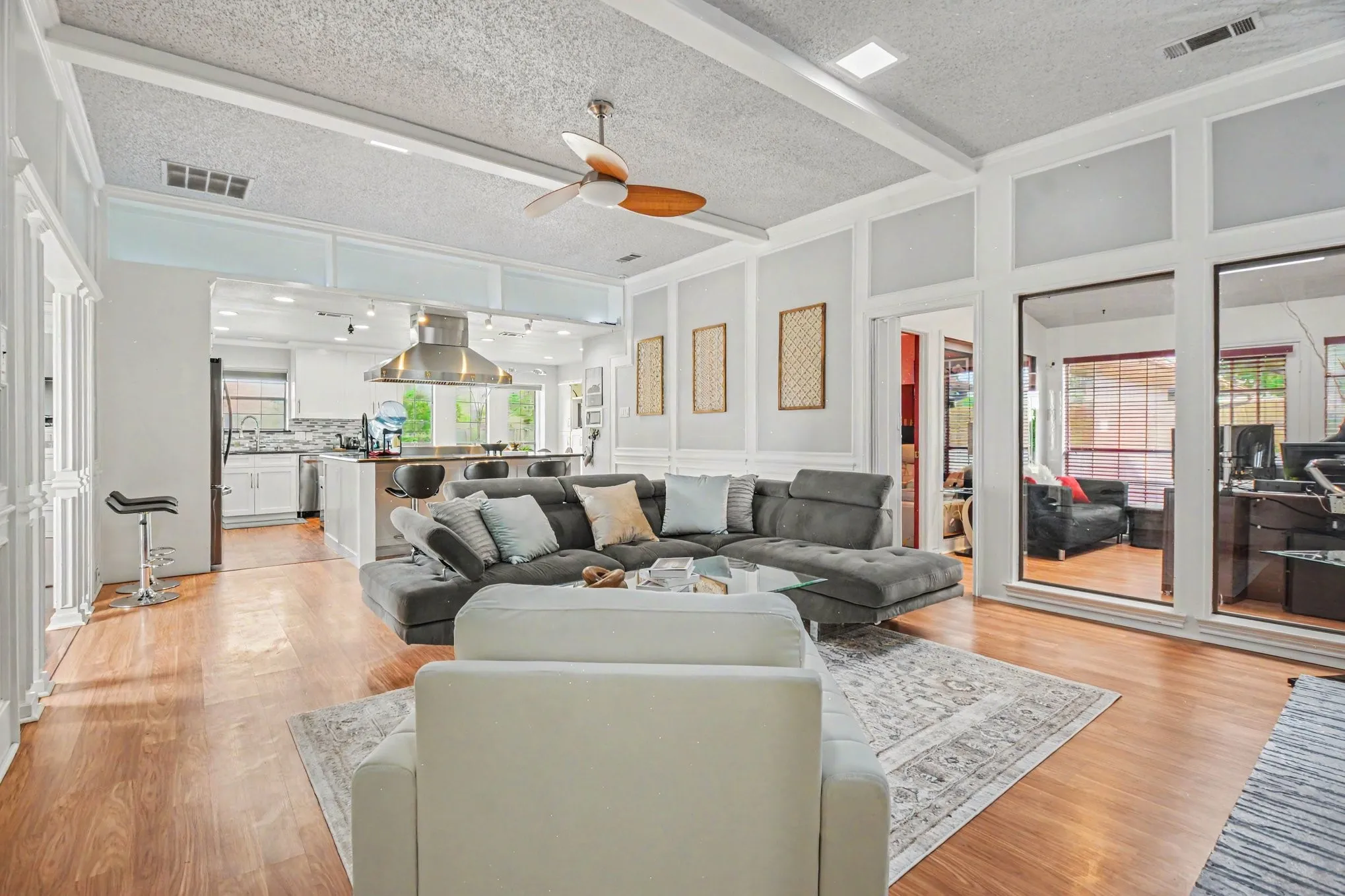 Spacious living area featuring wood-finish flooring, recessed lighting, and a ceiling fan