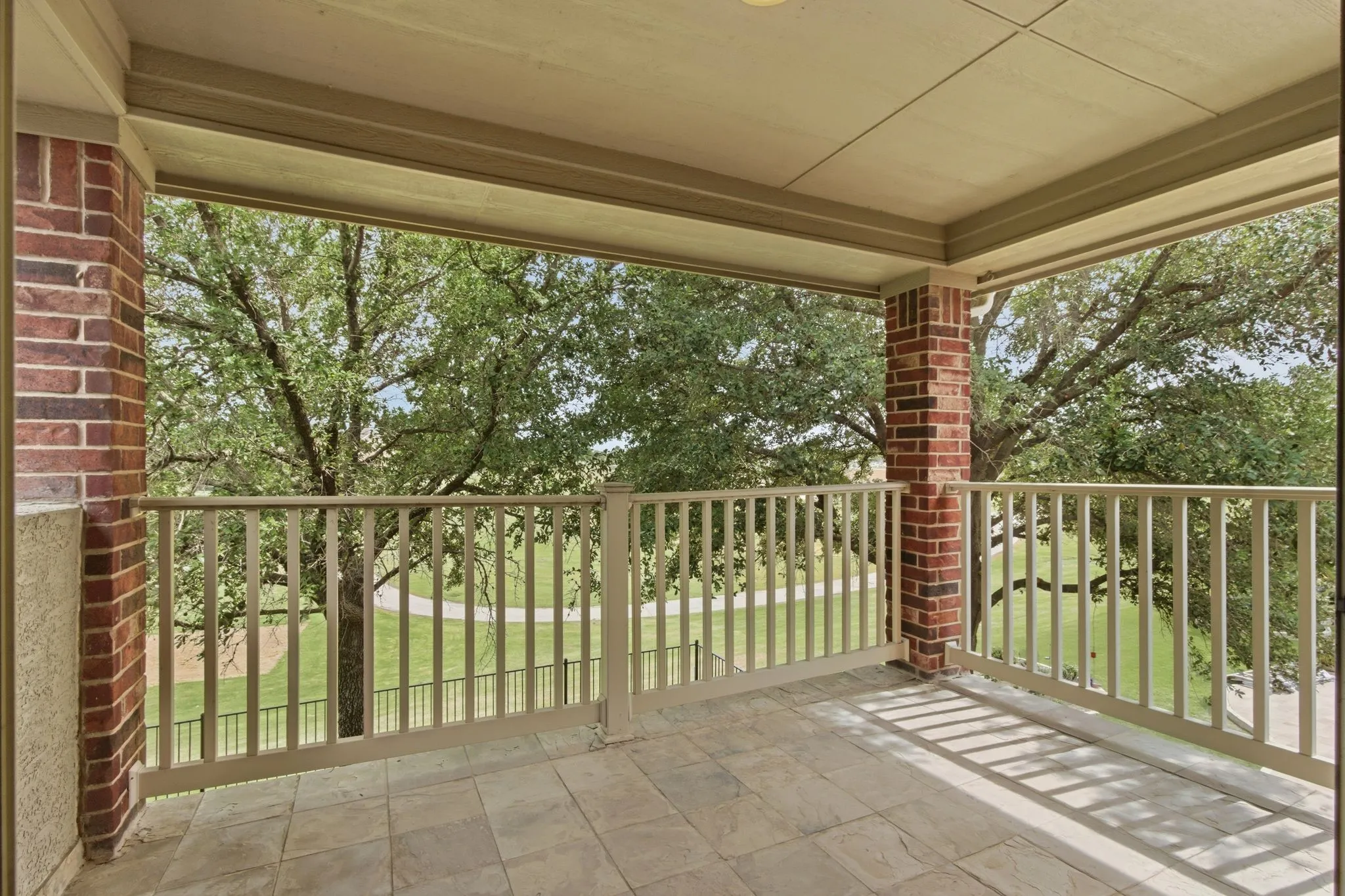 Covered outdoor patio featuring tile flooring, and a baluster railing.