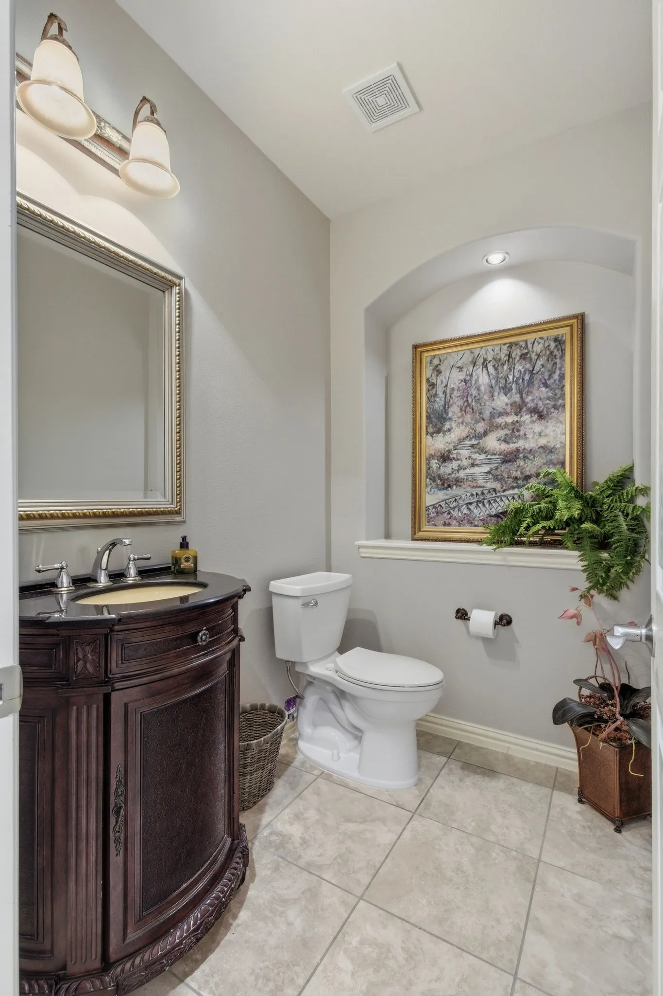 Hall Bathroom featuring a dark wood-finish vanity with an undermount sink and dark countertop
