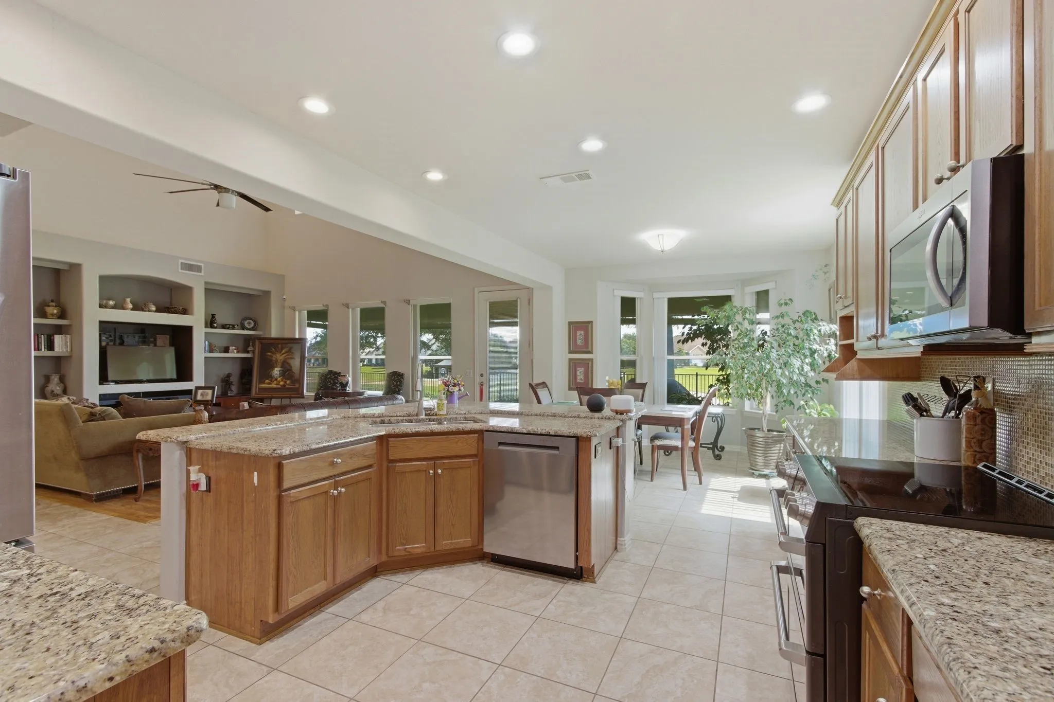 Kitchen featuring extensive wood cabinetry, granite-finish countertops, and a mosaic tile backsplash