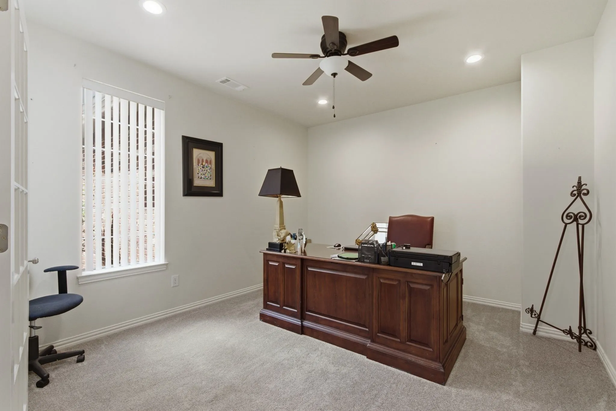 Carpeted study with lots of natural light with recessed lighting and a ceiling fan