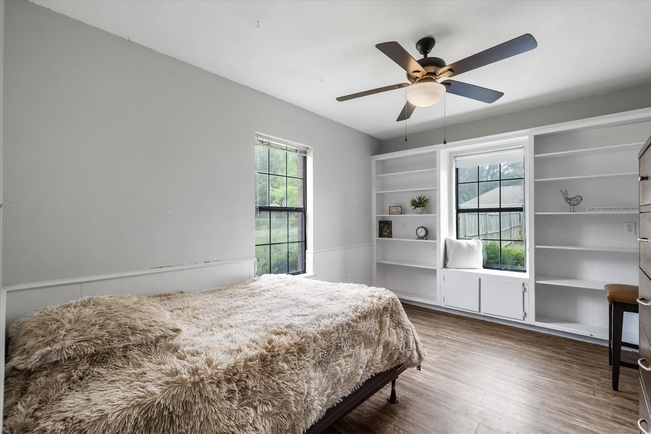 Spacious bedroom with built-in shelving, window seat and walk-in closet.