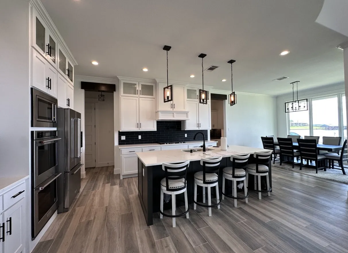 Kitchen featuring stainless steel appliances, backsplash, dark wood-style flooring, a kitchen bar, and recessed lighting