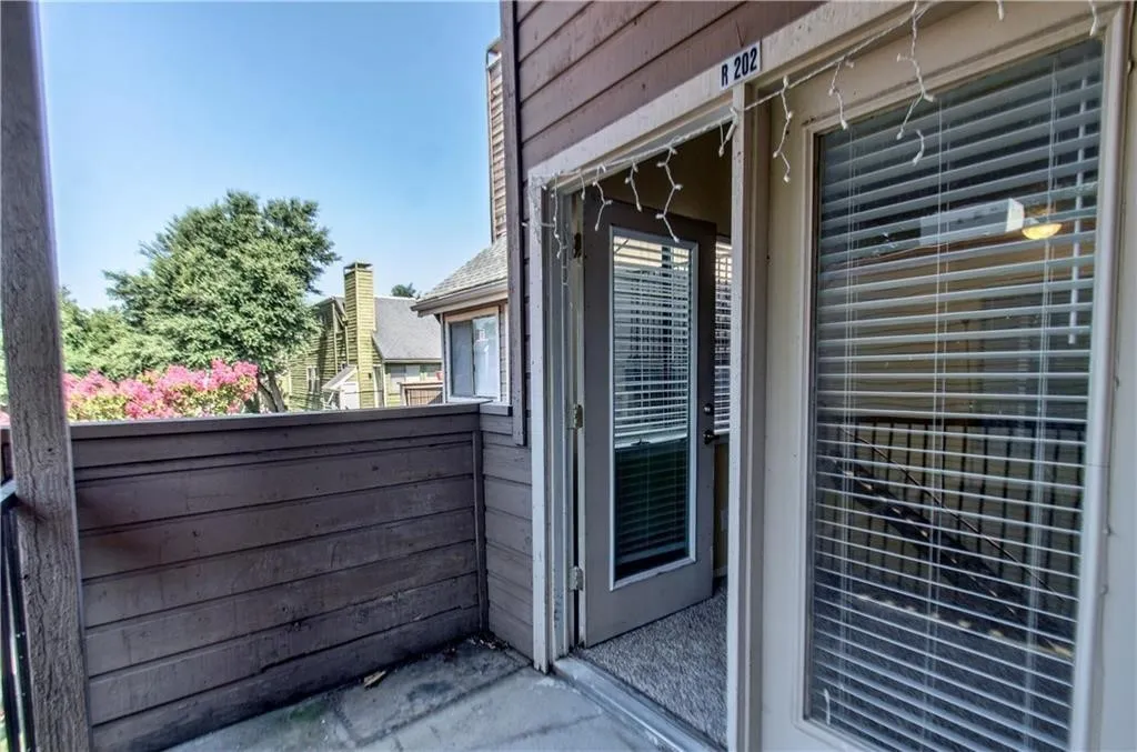 Private balcony featuring horizontal siding, a concrete floor, and direct access to interior spaces through a glass-paneled door and a large window