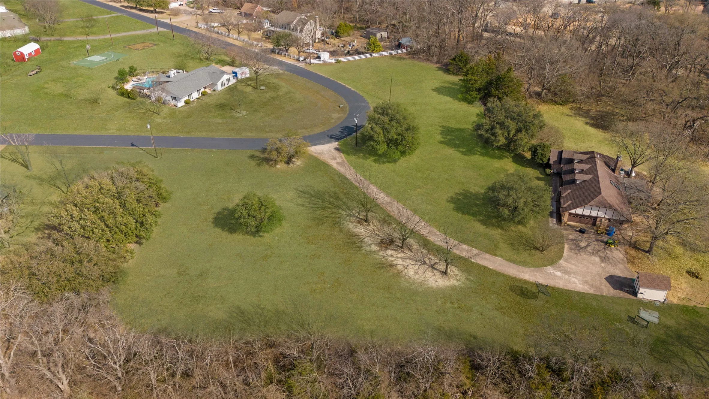 Expansive property featuring a winding paved driveway and a separate gravel path