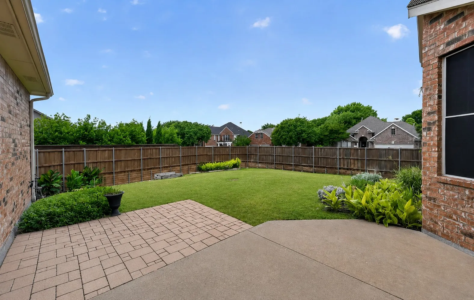 Extended patio overlooking landscaped yard.
