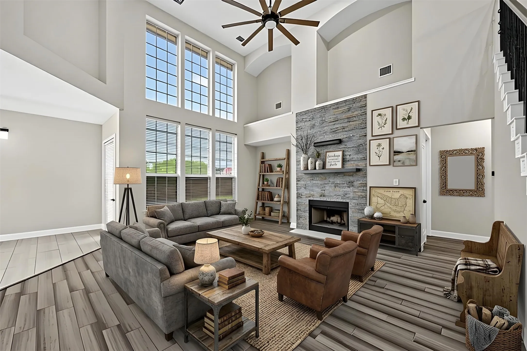 Two-story living area featuring a stacked stone fireplace with a wood mantel, wood-finish flooring, and a contemporary ceiling fan