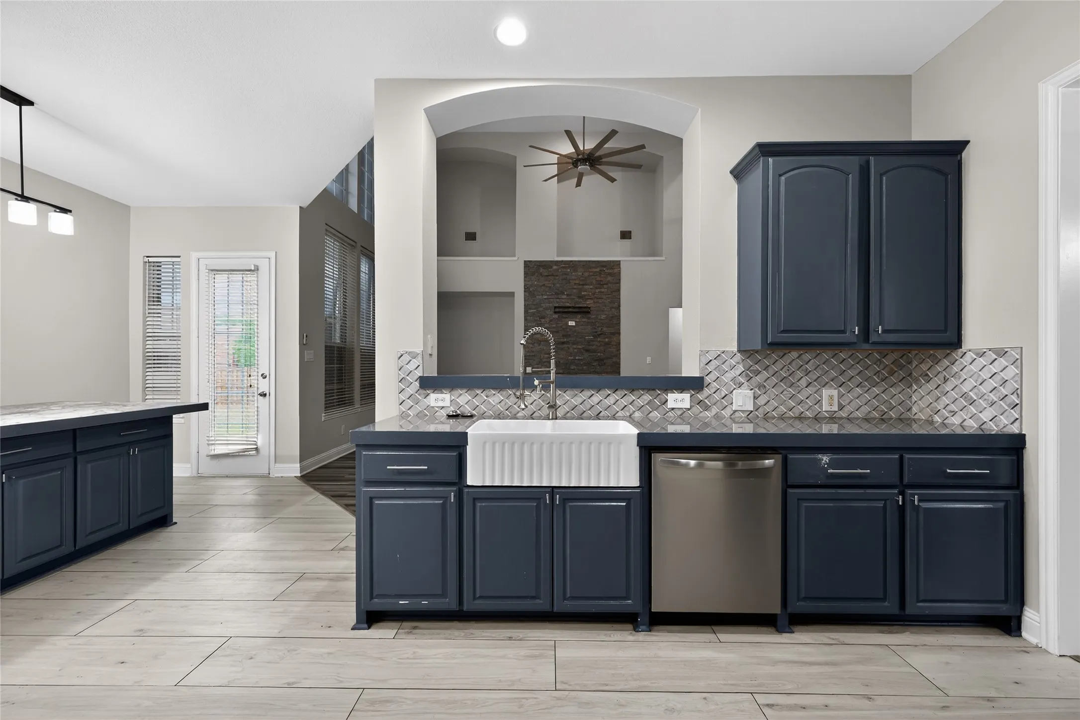 Open kitchen with farmhouse sink, and large island with storage space.