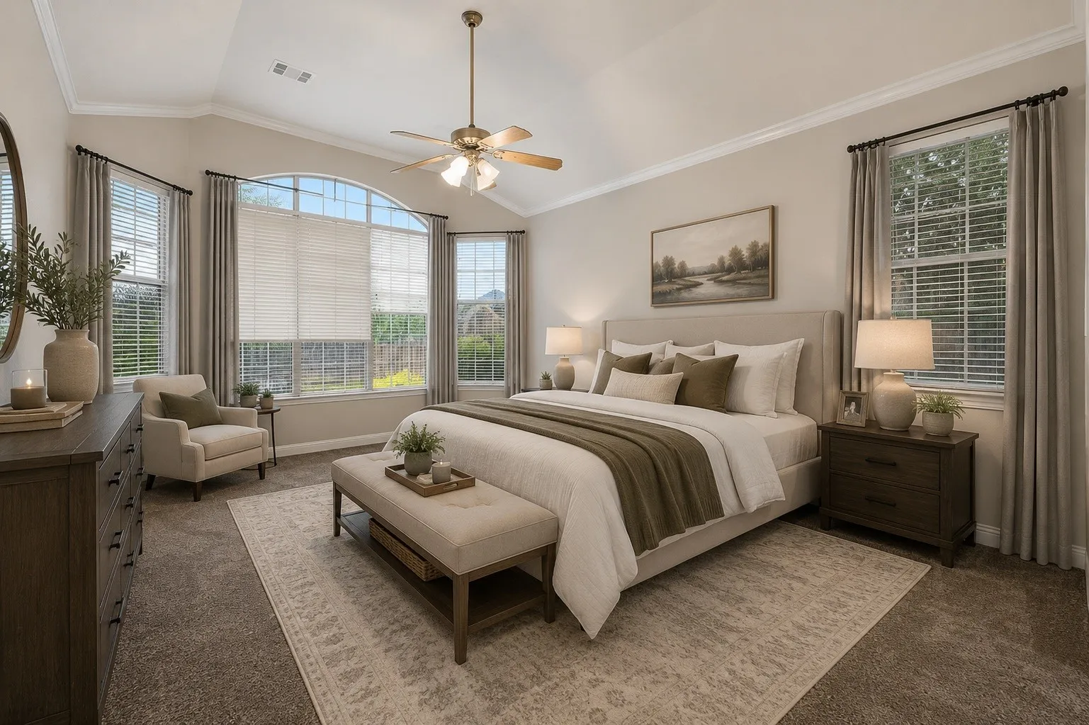 Vaulted ceiling with crown molding, ceiling fan with integrated lighting, large arched window, multiple windows with blinds, and carpeted flooring