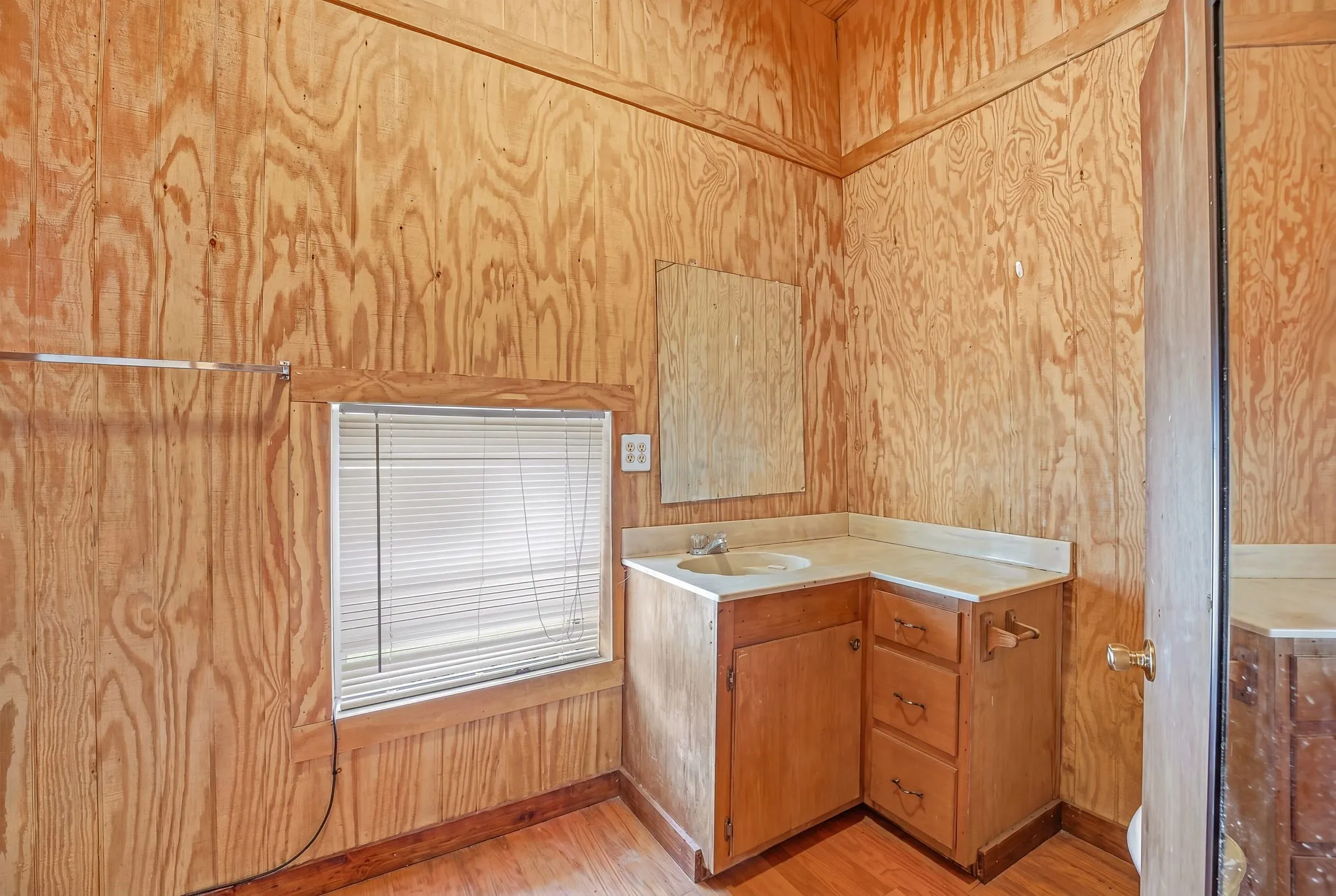 Room with plywood paneling and wood-finish flooring