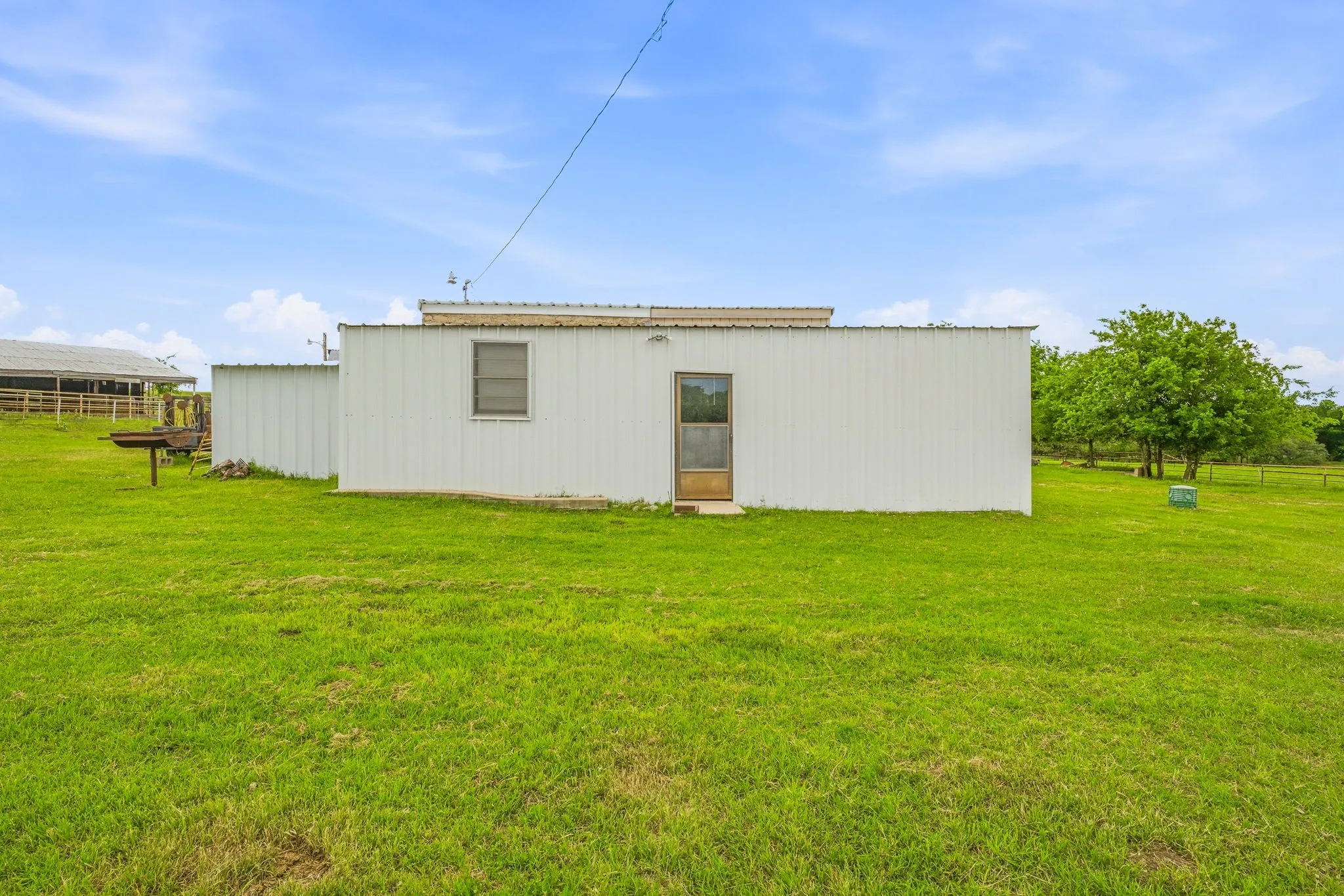 White metal siding structure with a corrugated metal roof