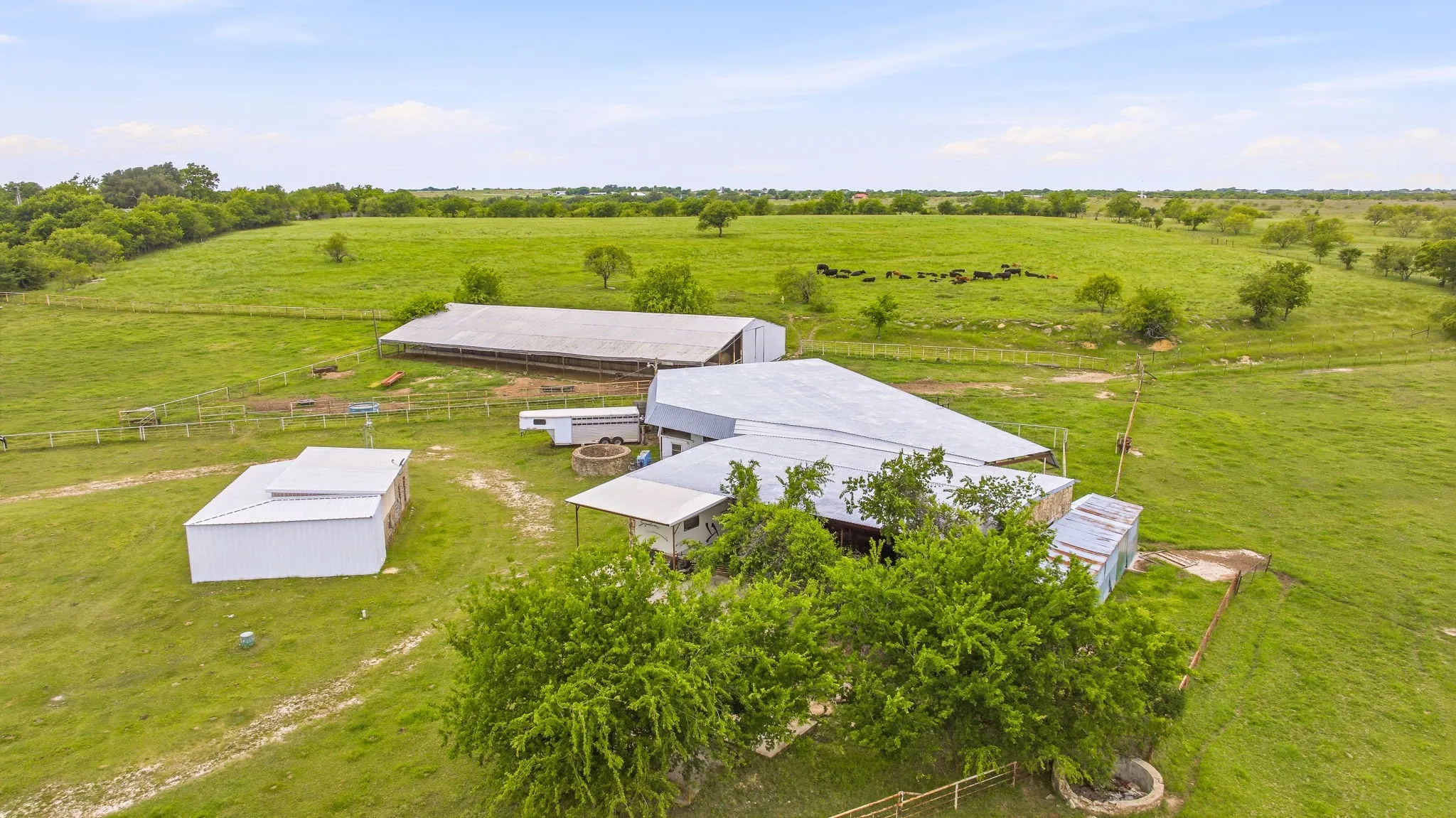 Expansive green acreage featuring multiple outbuildings with metal roofing