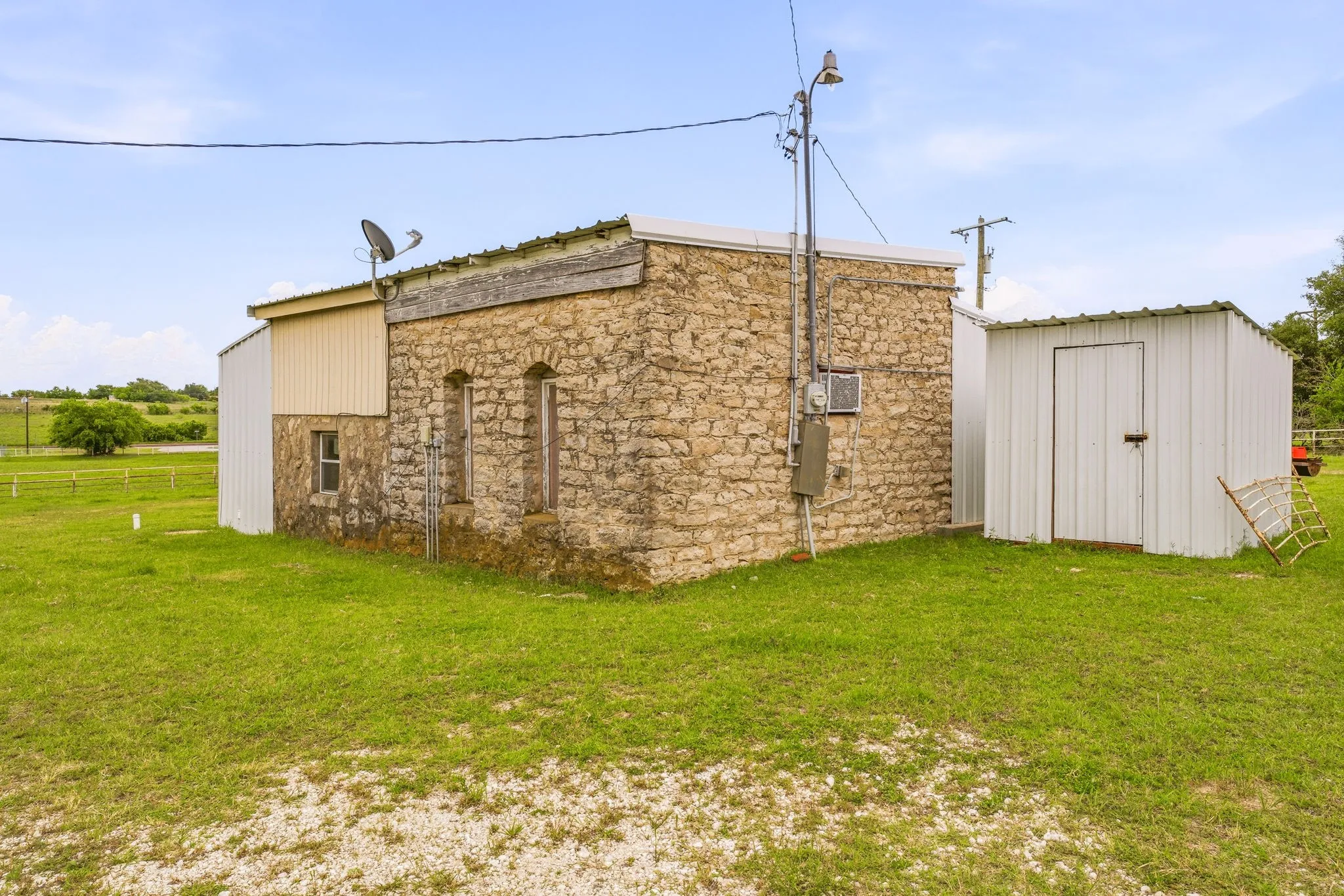 Stone structure with a corrugated metal roof and an attached metal-sided extension