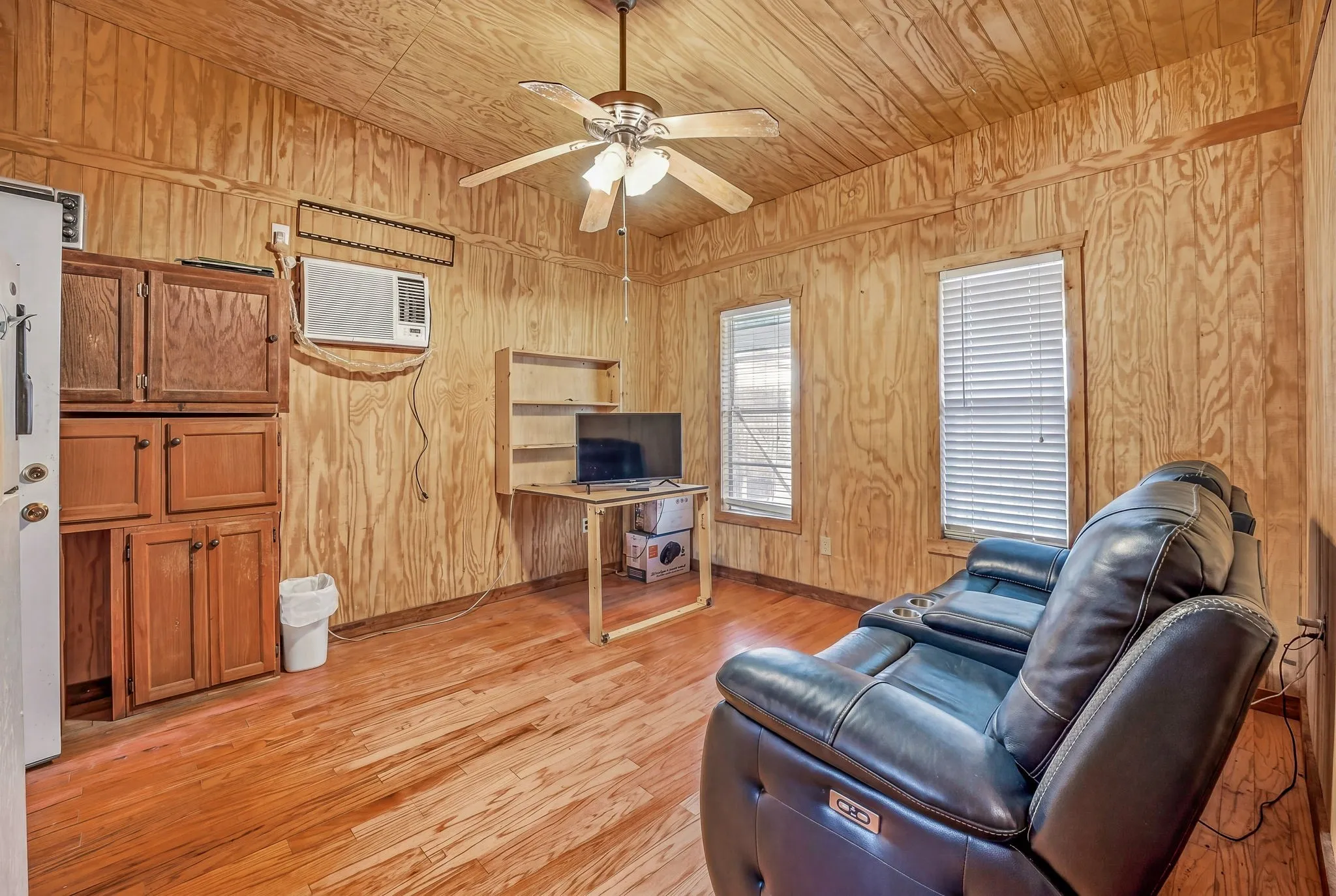 Wood-finish flooring throughout, complemented by wood-paneled walls and ceiling