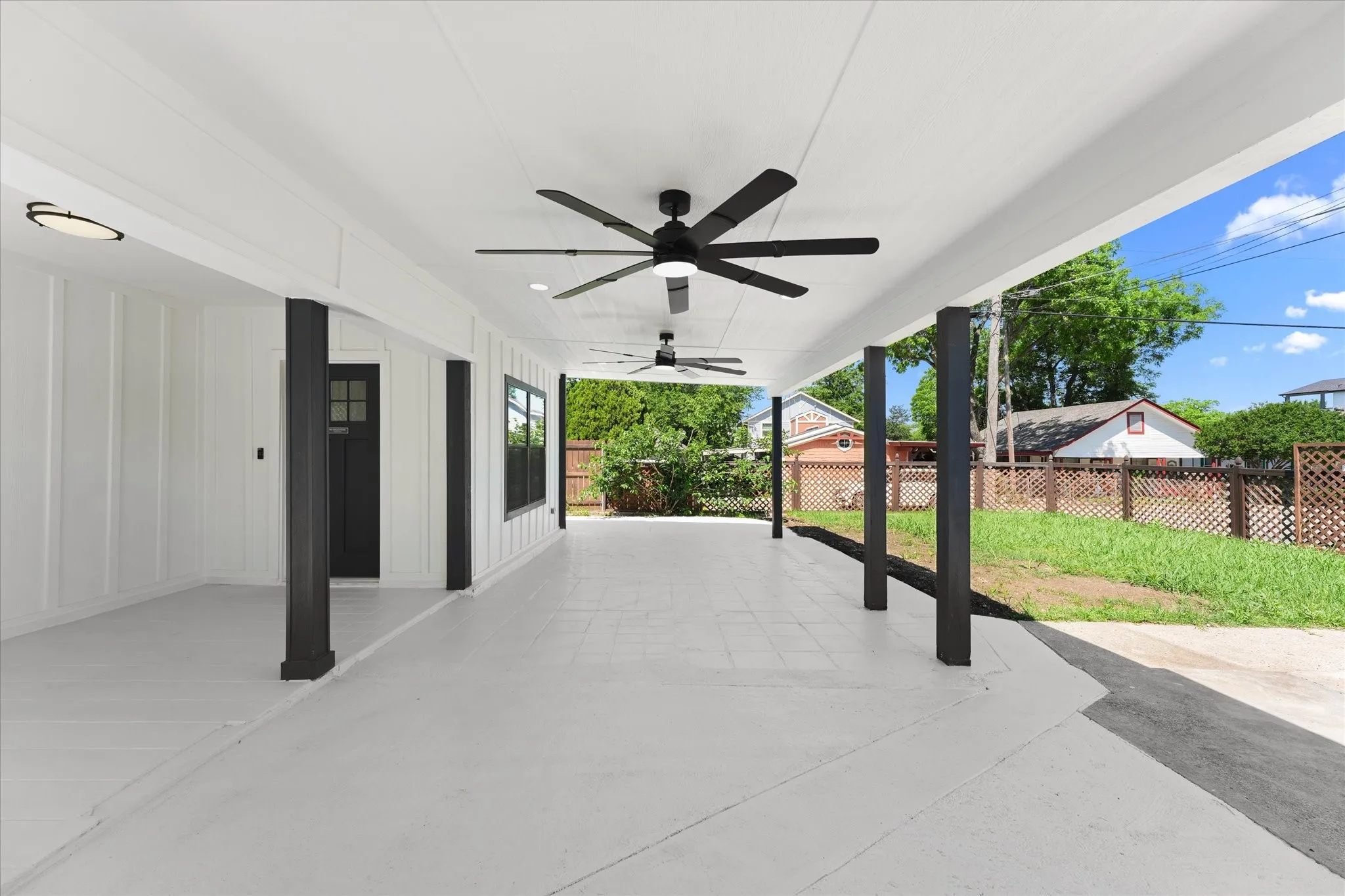 Expansive covered patio featuring a white finish, multiple ceiling fans, and recessed lighting