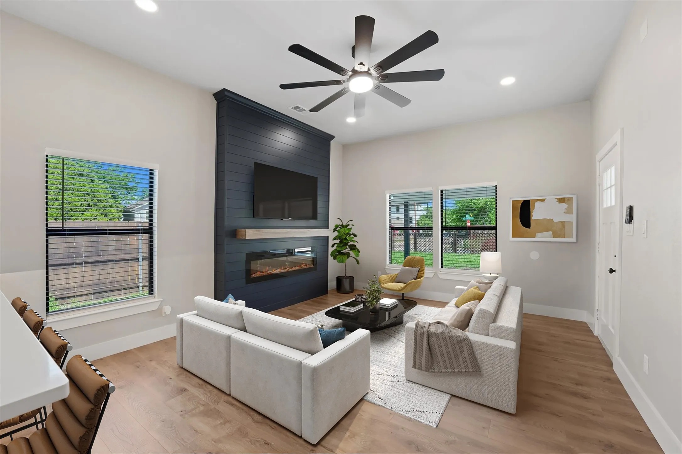 Living area featuring a floor-to-ceiling accent wall with a built-in electric fireplace and wood mantle