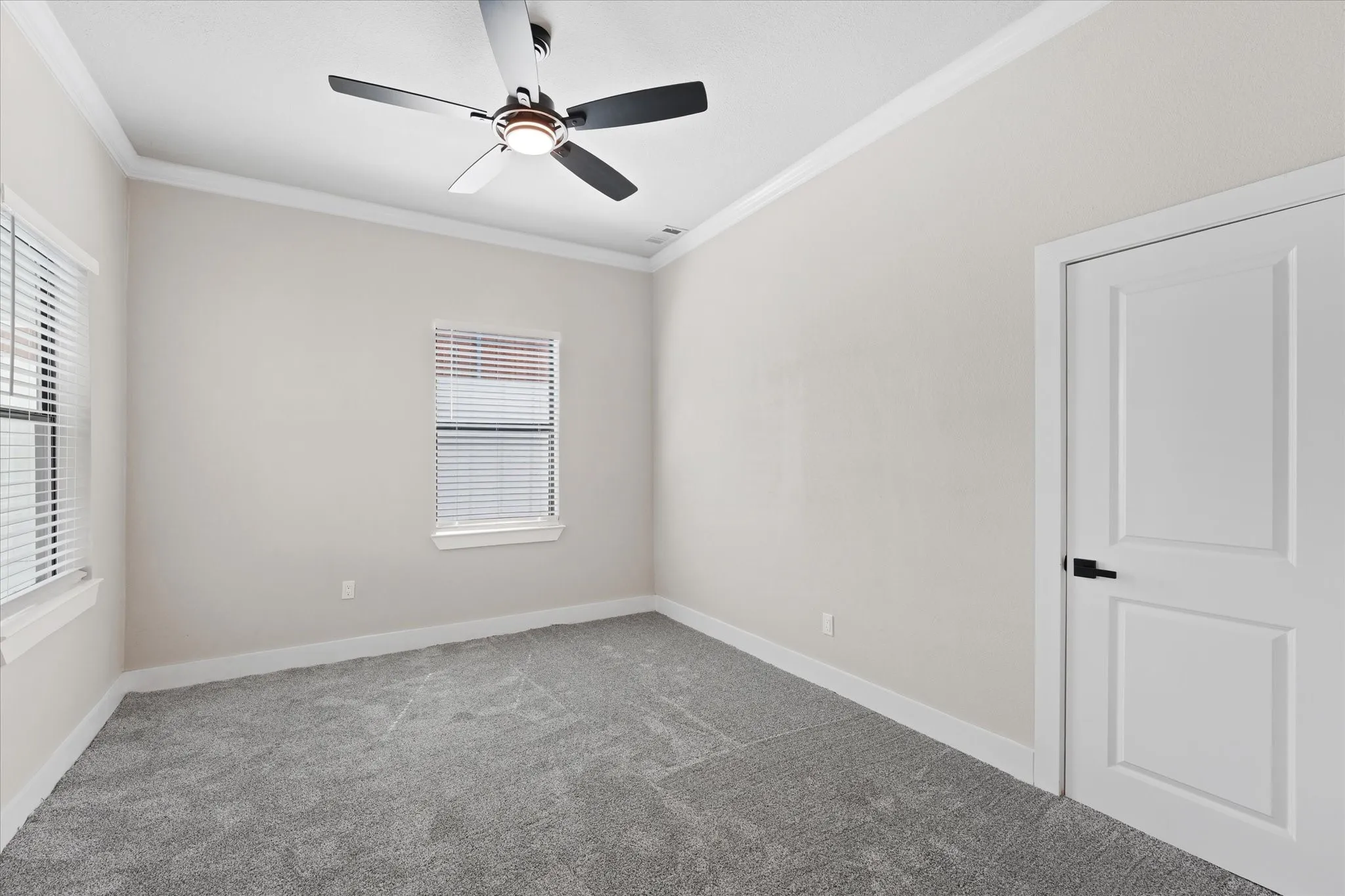 Room #1, featuring a ceiling fan with integrated lighting, two windows with blinds, crown molding, baseboards, and neutral-toned wall-to-wall carpeting